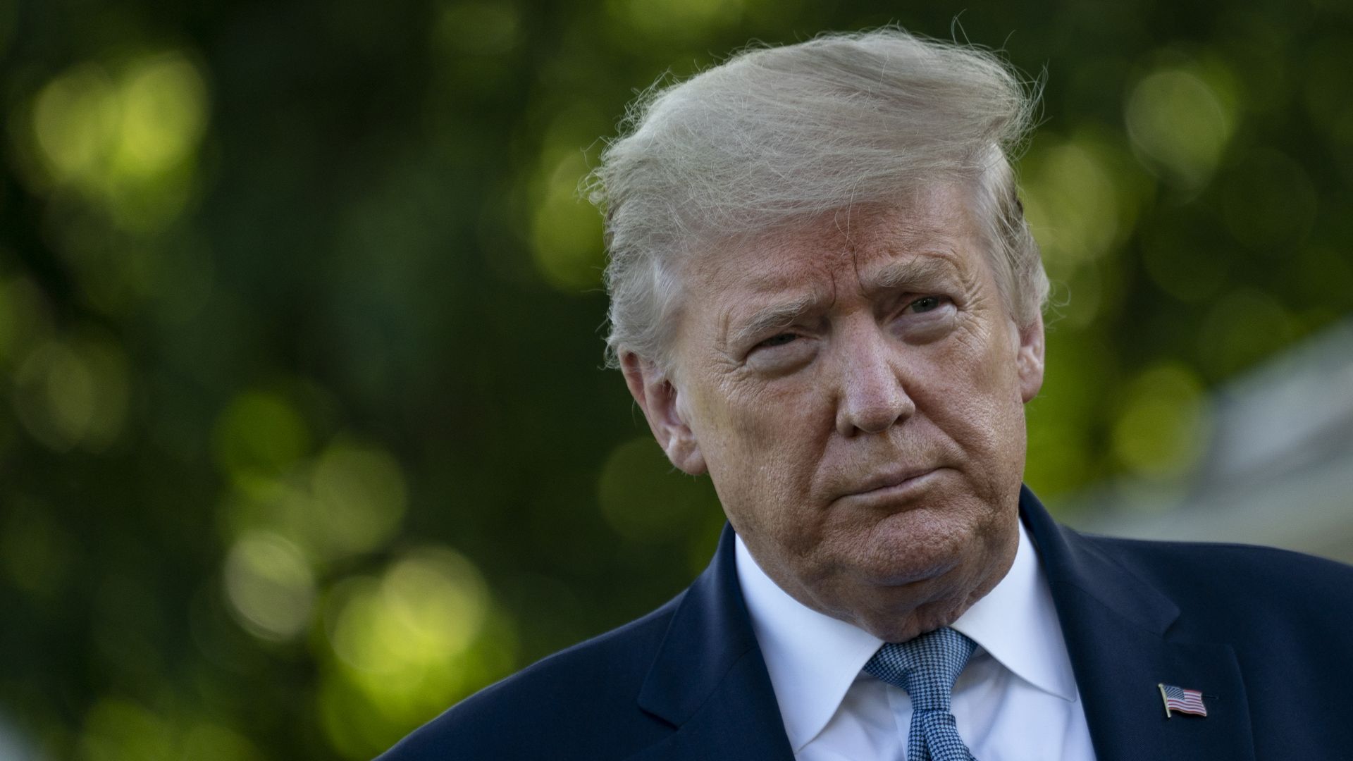 In this image, Trump walks and wears a suit