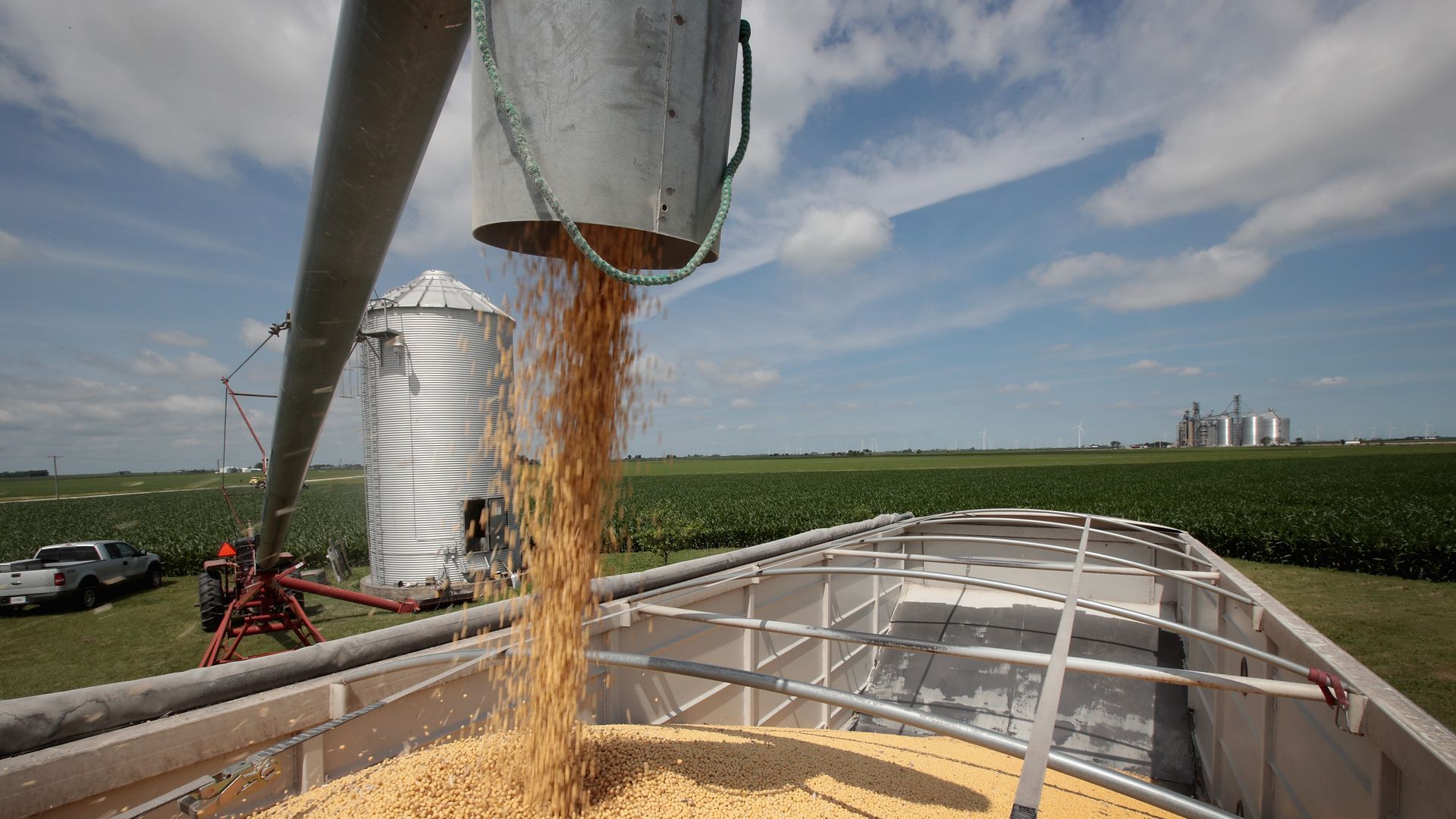 A bucket dumps soybeans into a truck