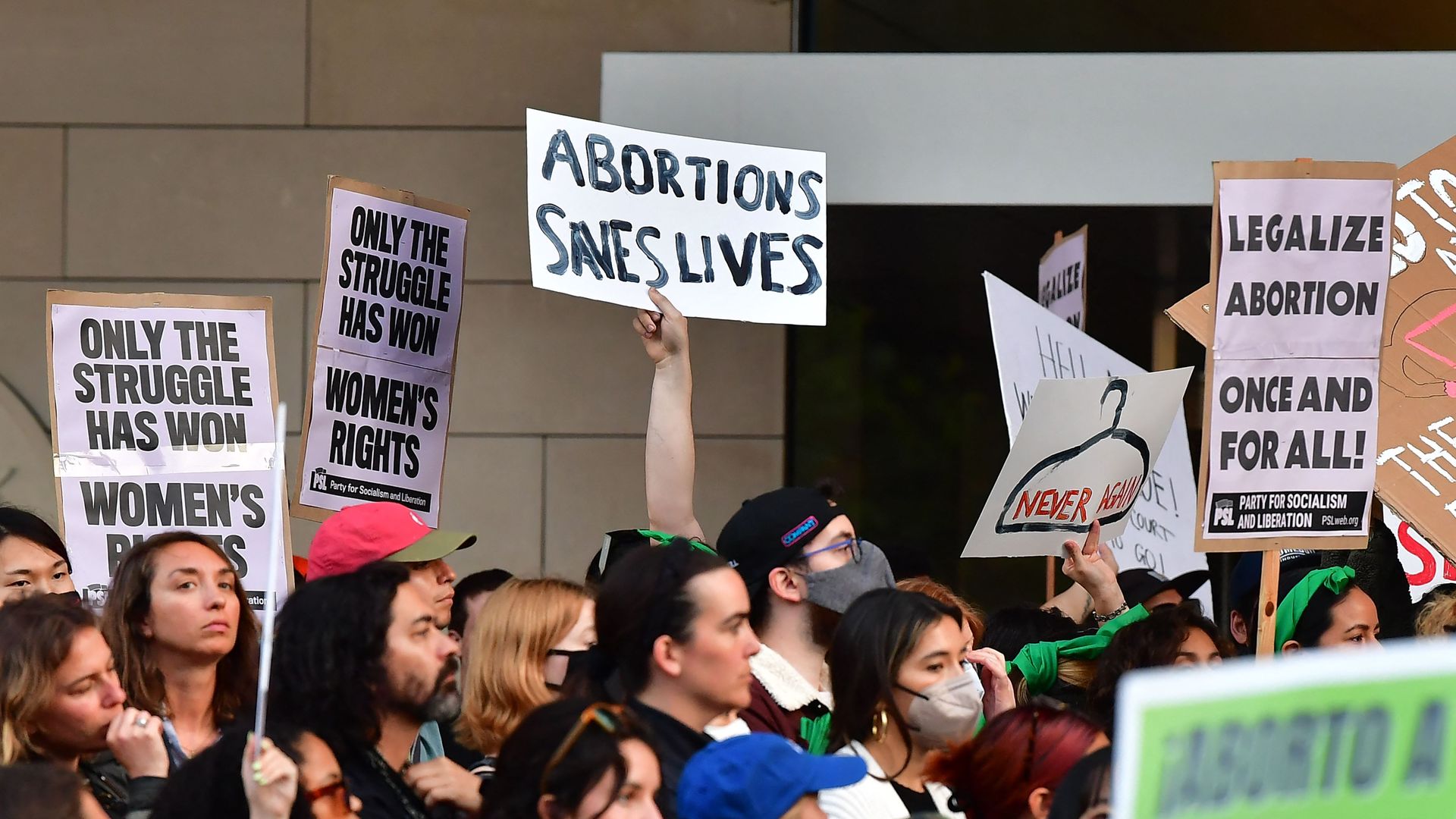Picture of an abortion rights protest with a person holding a sign that says "abortion saves lives"