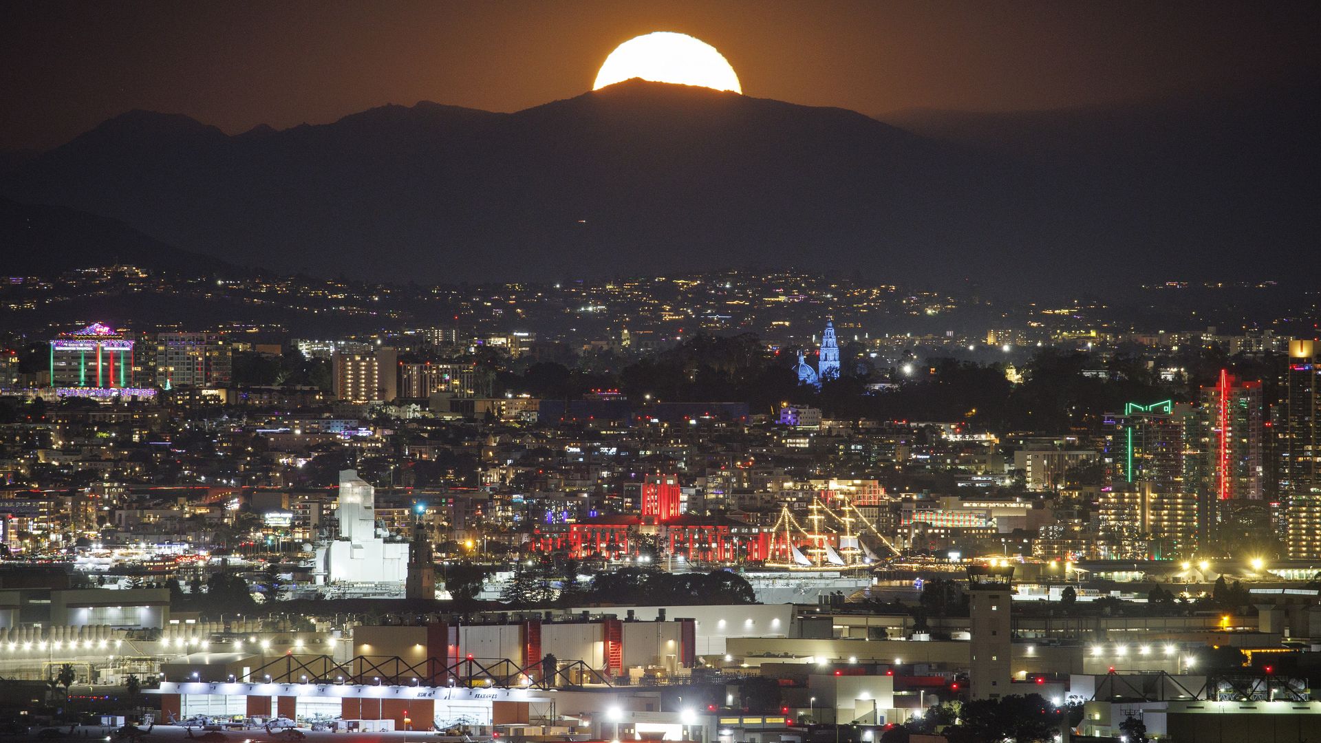 SAN DIEGO, CALIFORNIA - DECEMBER 5: A full Cold Moon supermoon rises behind downtown and Naval Air Station North Island in the foreground on December 5, 2025 in San Diego, CA. (Photo by Kevin Carter/Getty Images)