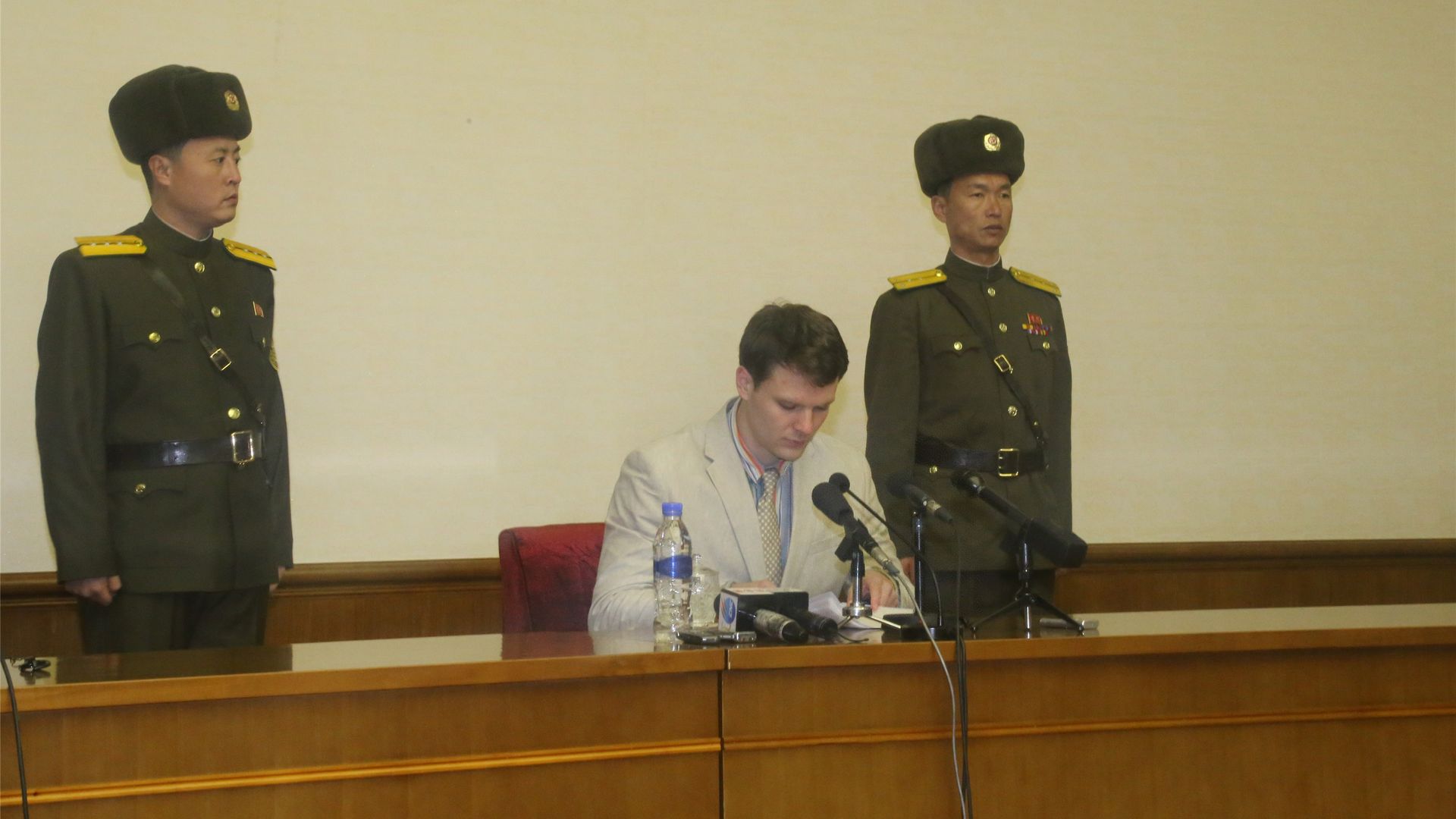 In this image, Otto Warmbier testifies while sitting between two North Korea officers. 