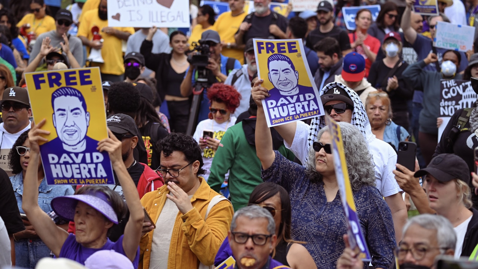 Protesters holding signs that says "Free David Huerta" at a rally