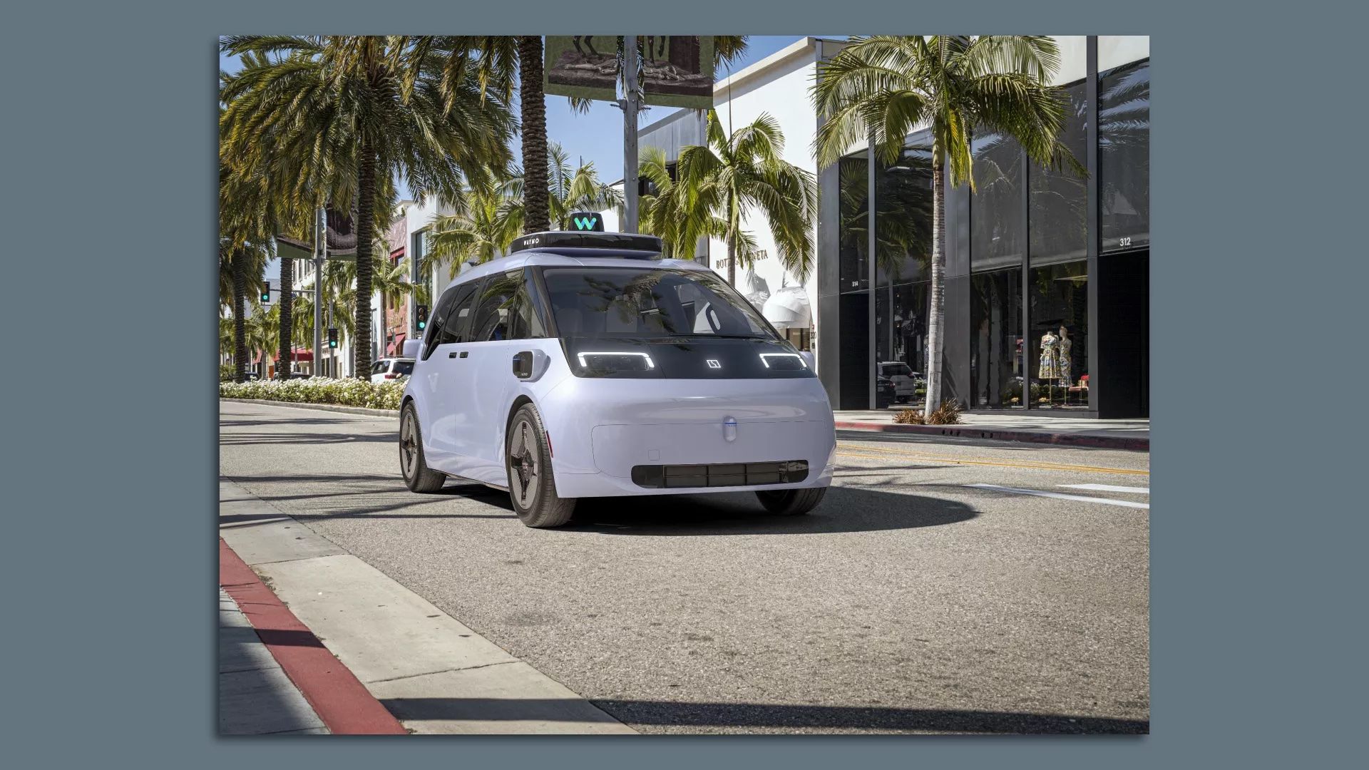 A Waymo robotaxi driving down the street. 