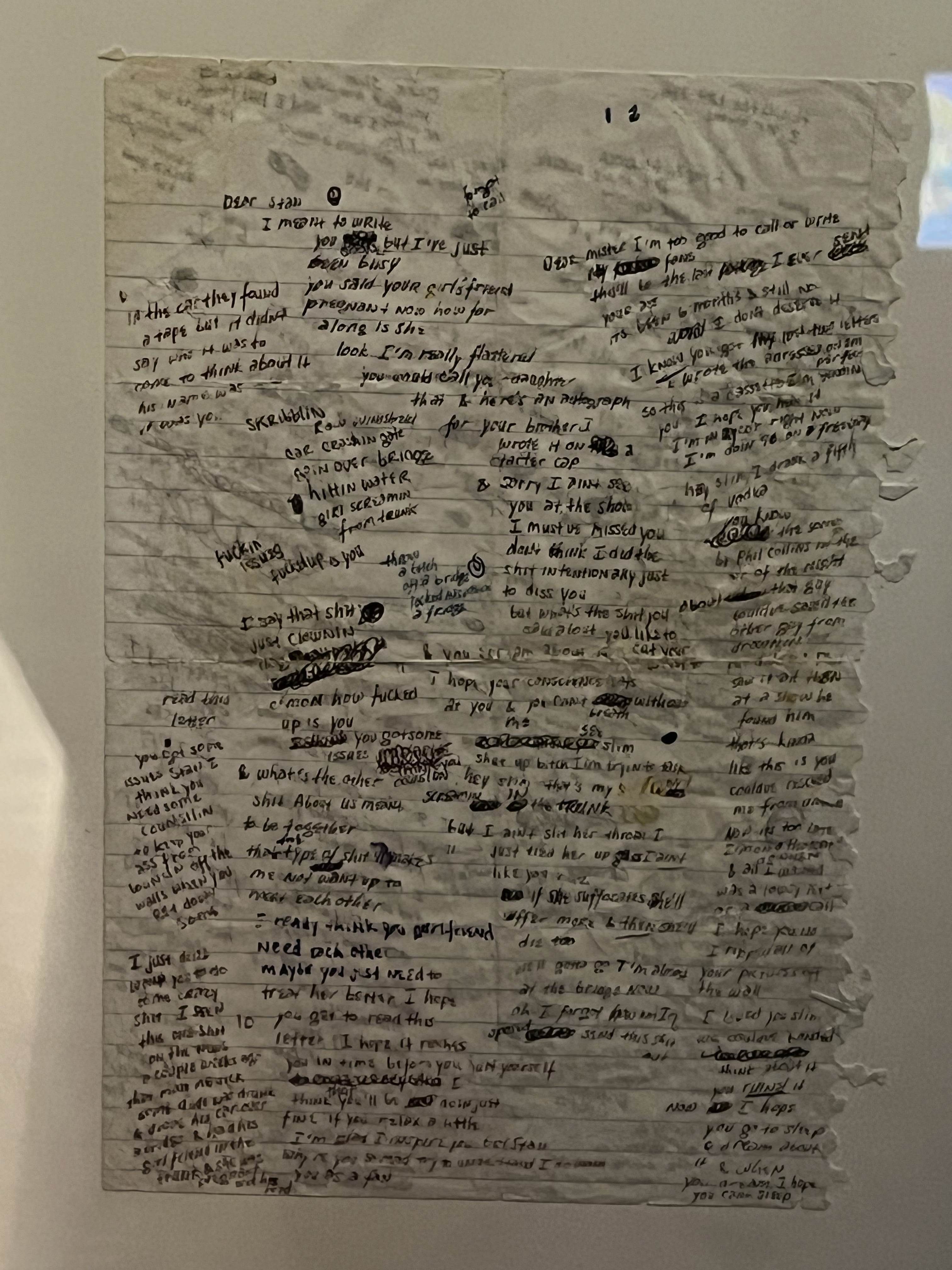 A piece of note paper with lyrics written in ink.