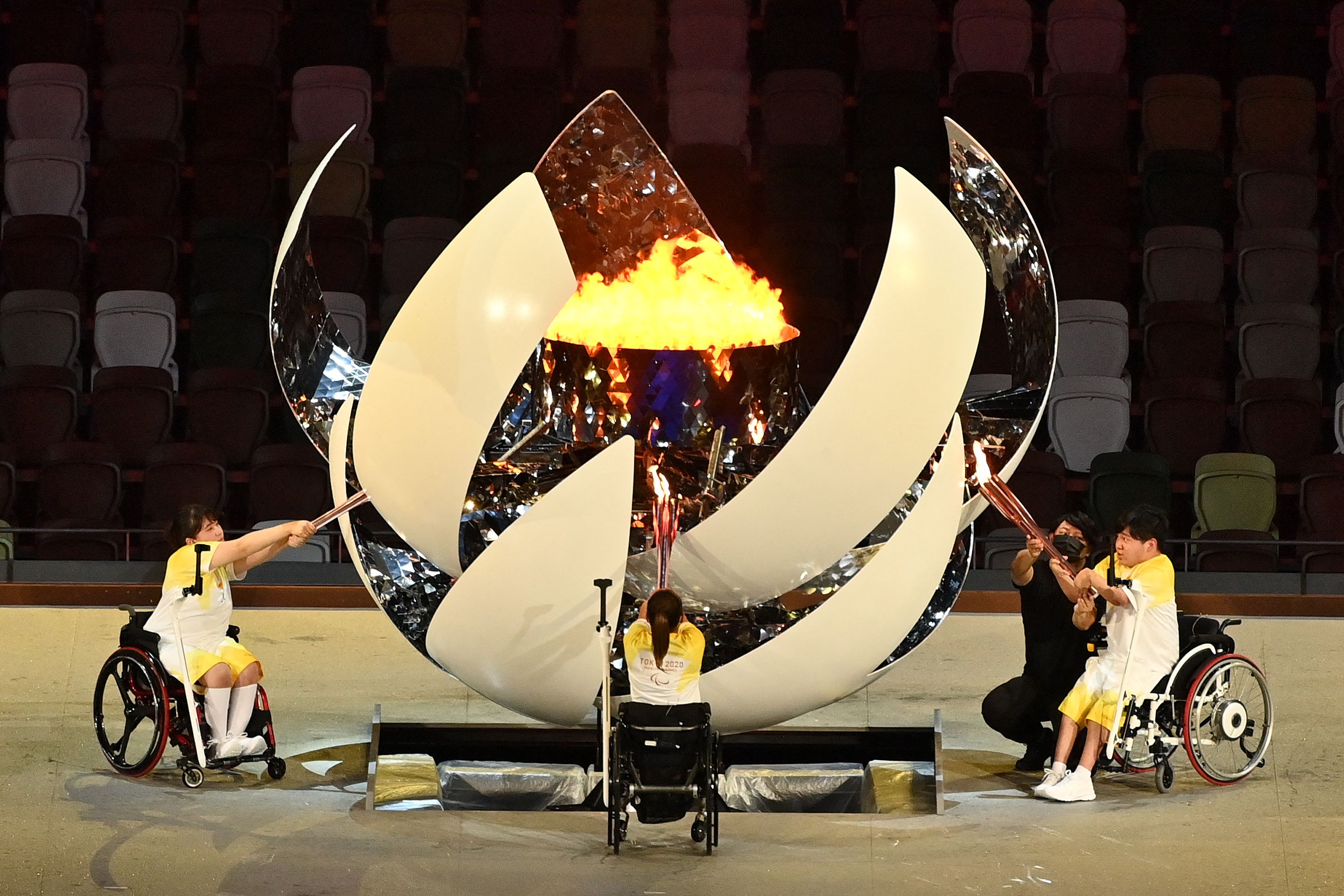 Three torchbearers light up the Paralympic cauldron during the opening ceremony 