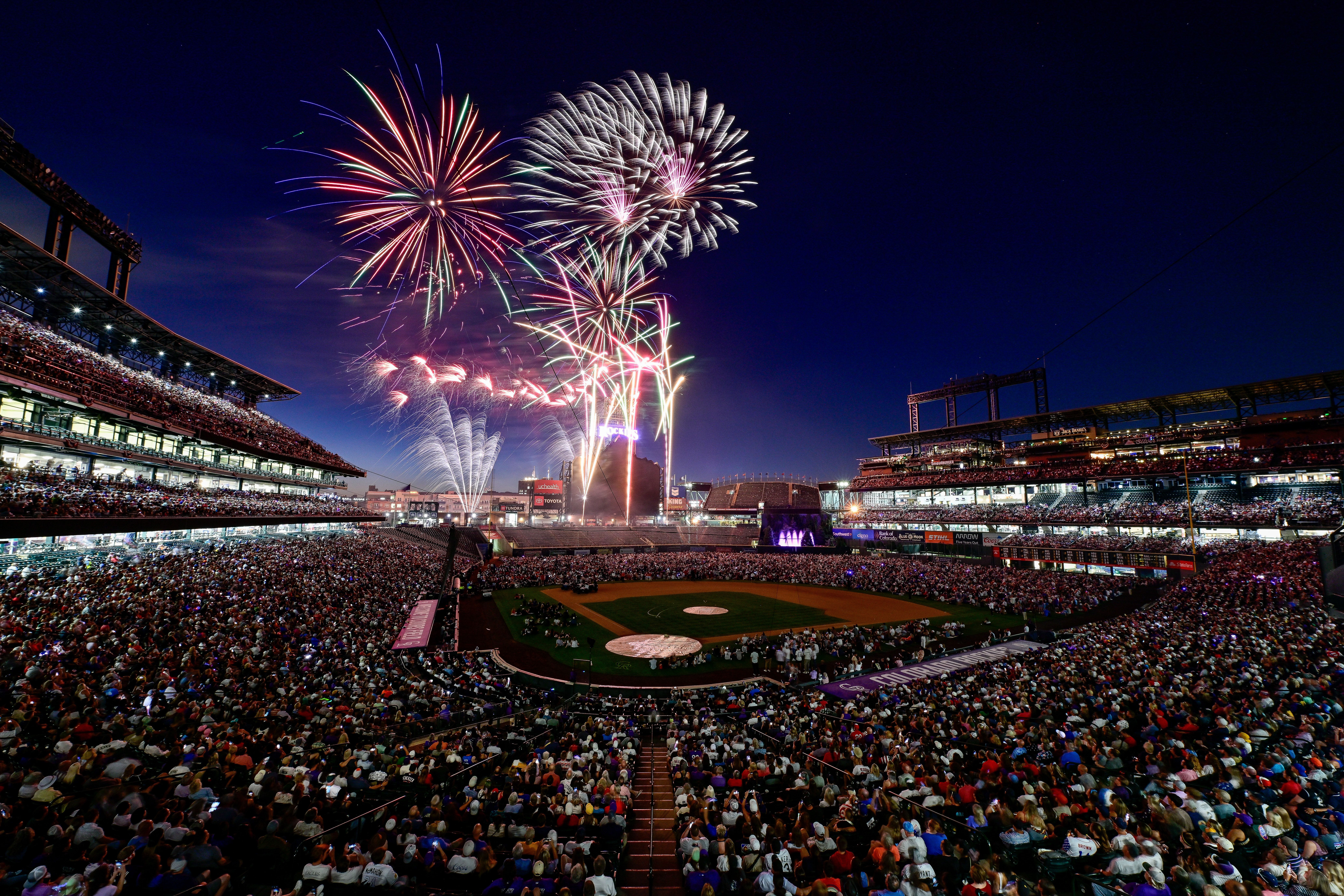 Fireworks explode over a baseball field. 