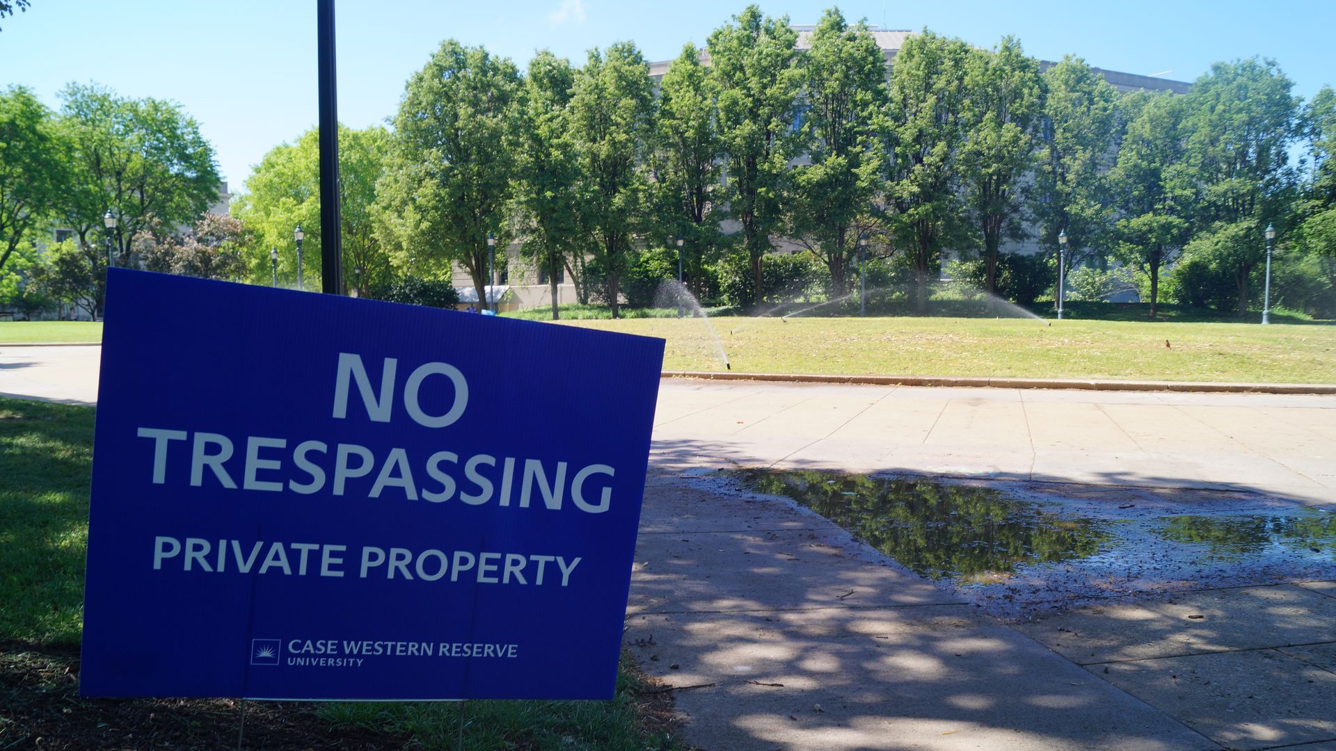 Blue sign with "No Trespassing Private Property" on it 