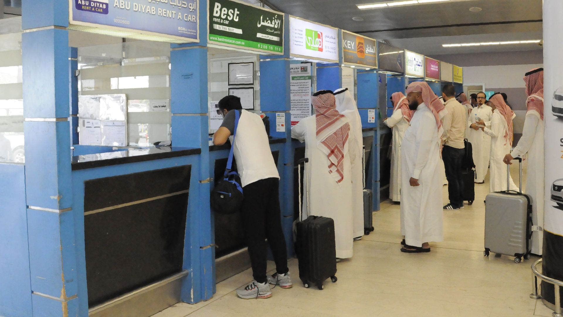 Travellers queue at car rental stands inside the Abha airport in the southern Saudi Arabian popular mountain resort of the same name , on July 2, 2019.