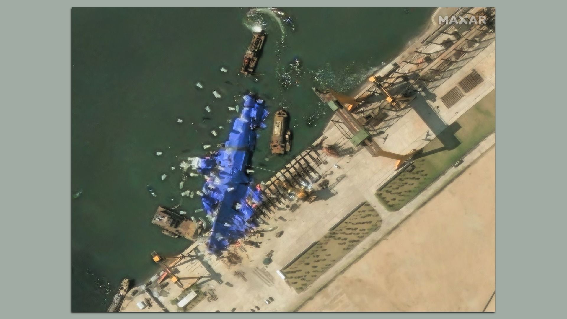 A satellite image show North Korean workers at a shipyard attempting to recover a warship that fell onto its side.