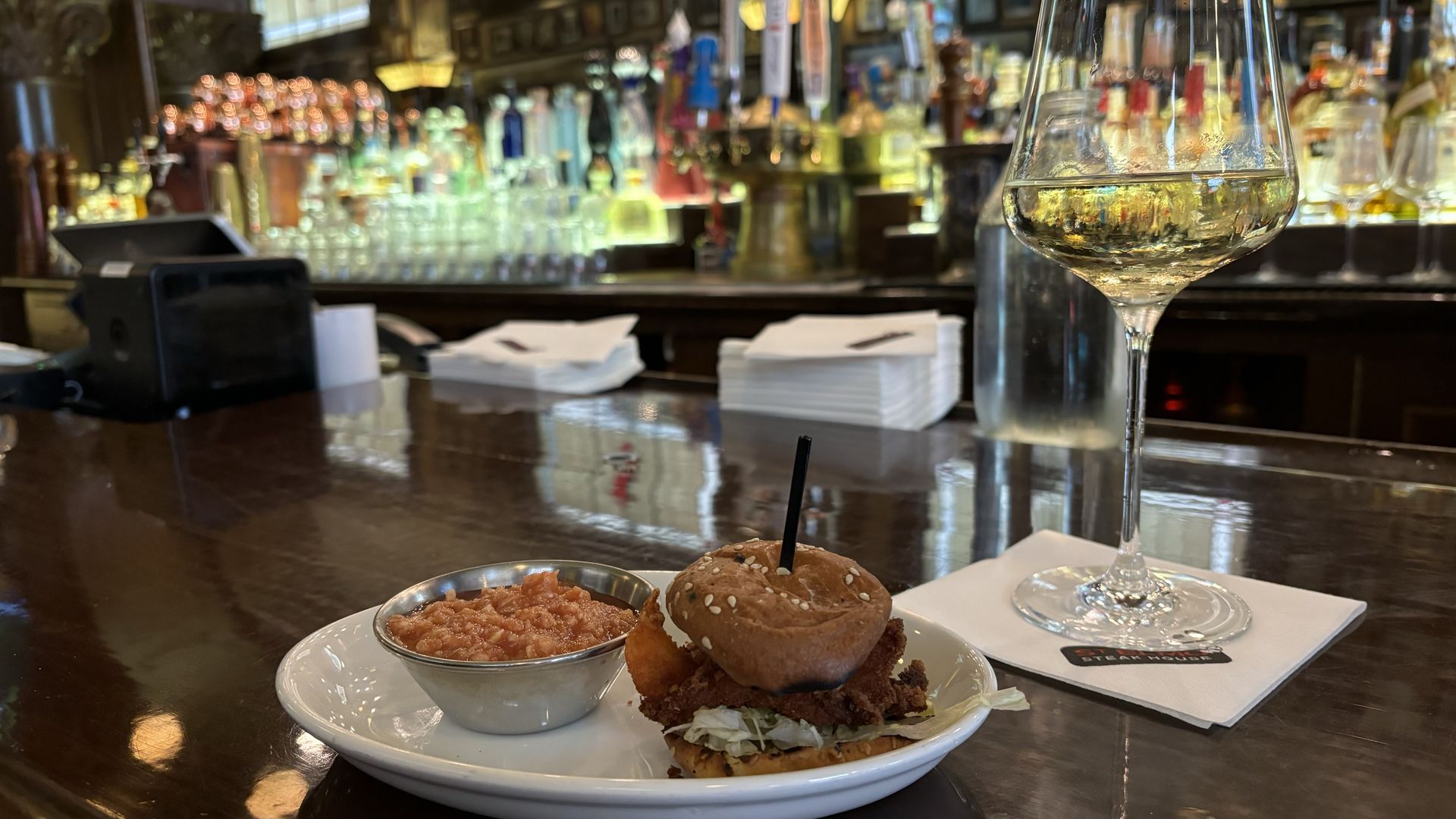A plate and glass of wine on a bar