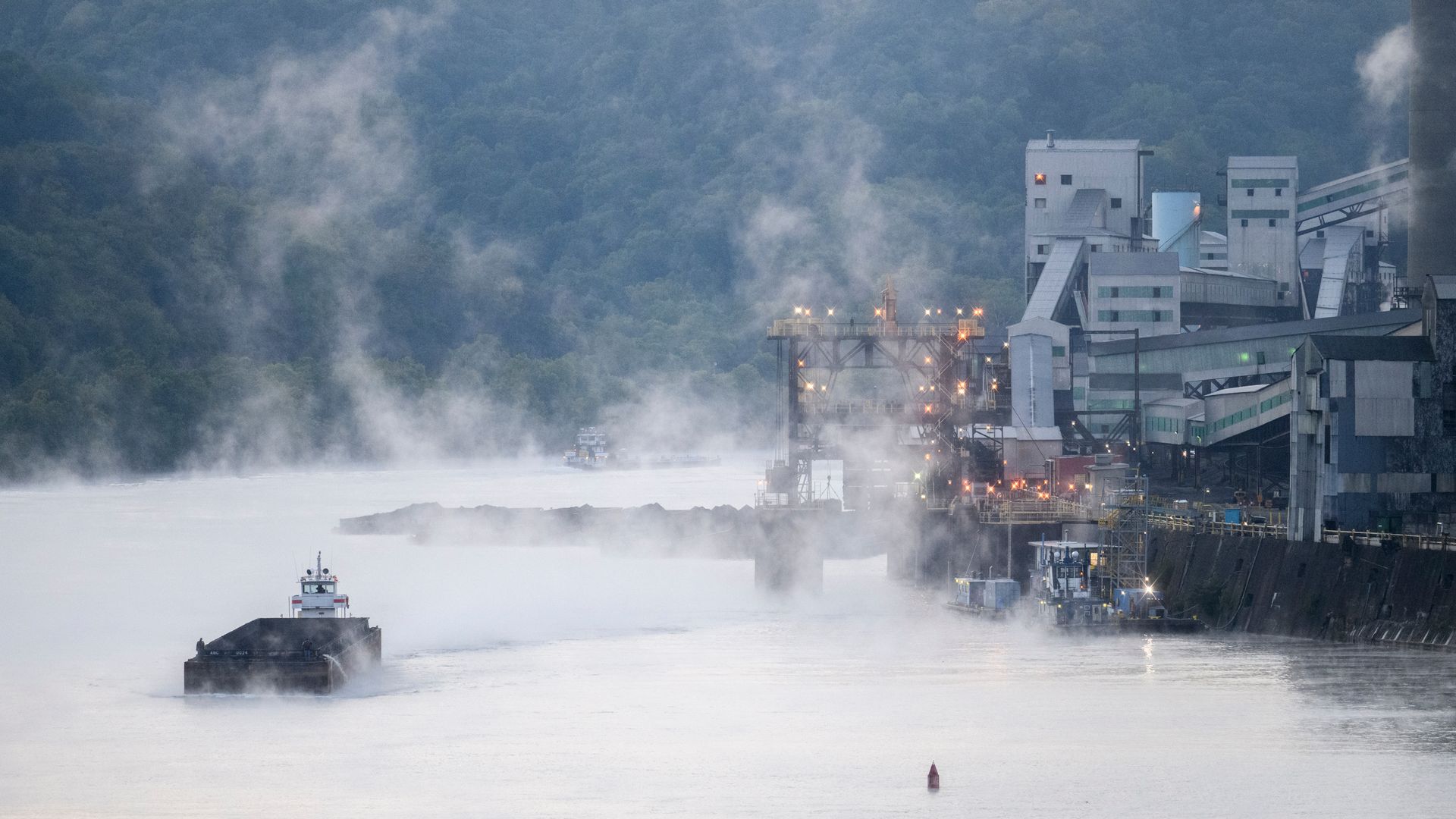 Mist coming off of a river with an industrial plant on the shore