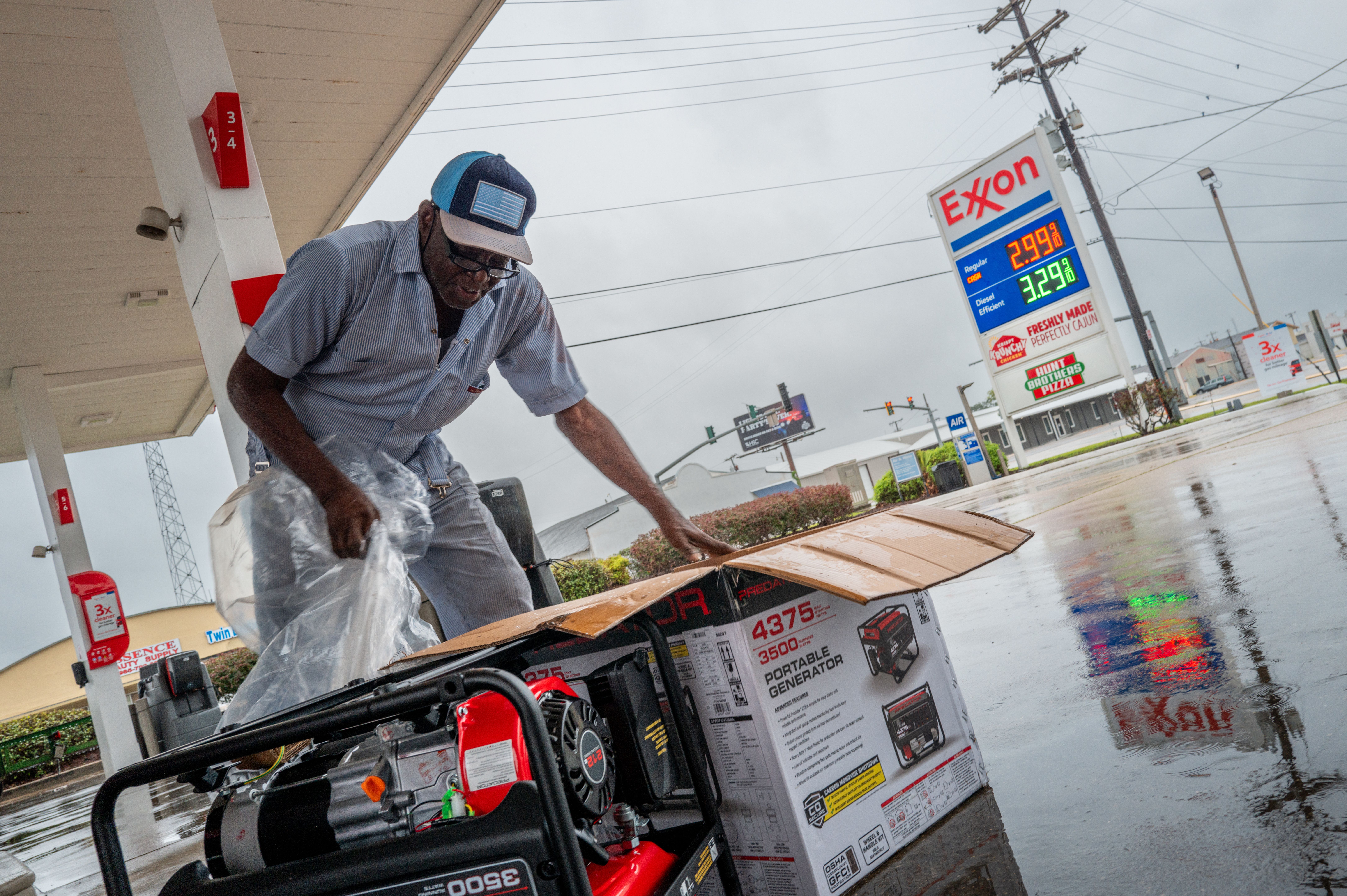 A man unwraps a generator at an Exxon gas station.