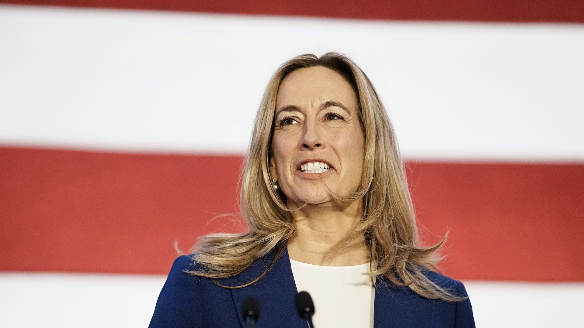 Mikie Sherrill smiles in front of a giant American flag