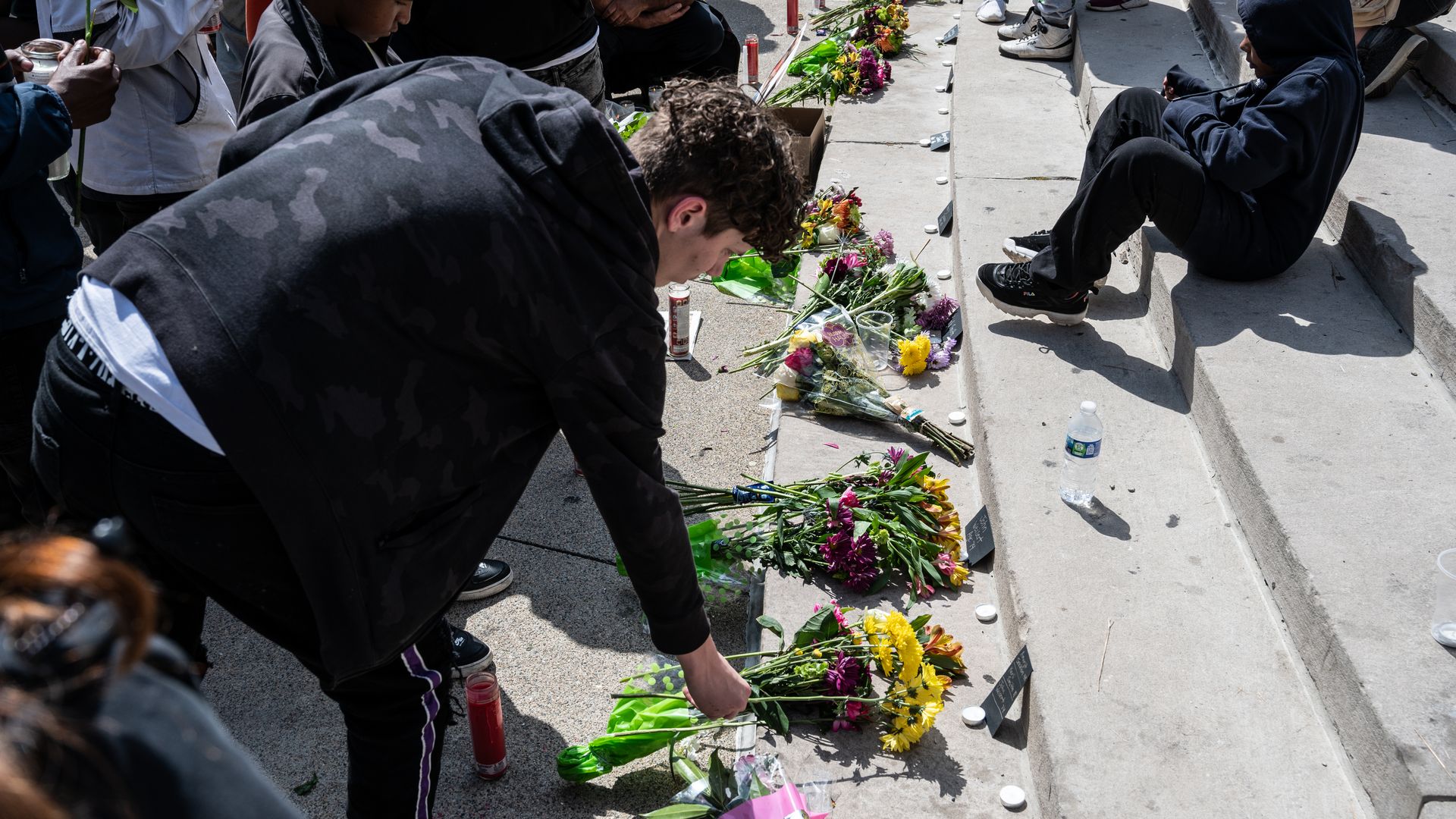  People lay flowers in honor of the deceased during a vigil in Indianapolis Sunday. 