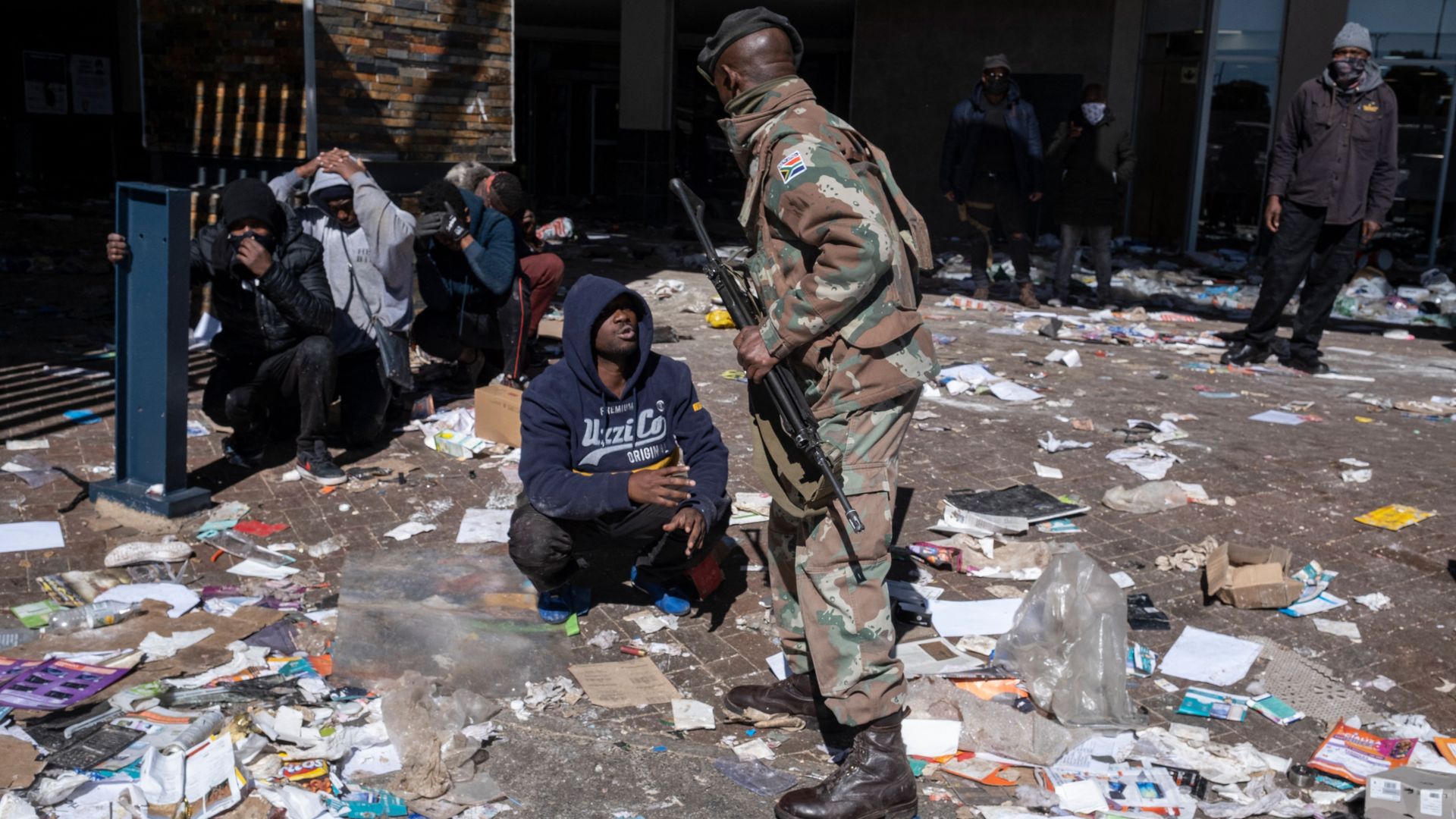 A suspected looter pleads with a South African National Defence Force (SANDF) soldier.