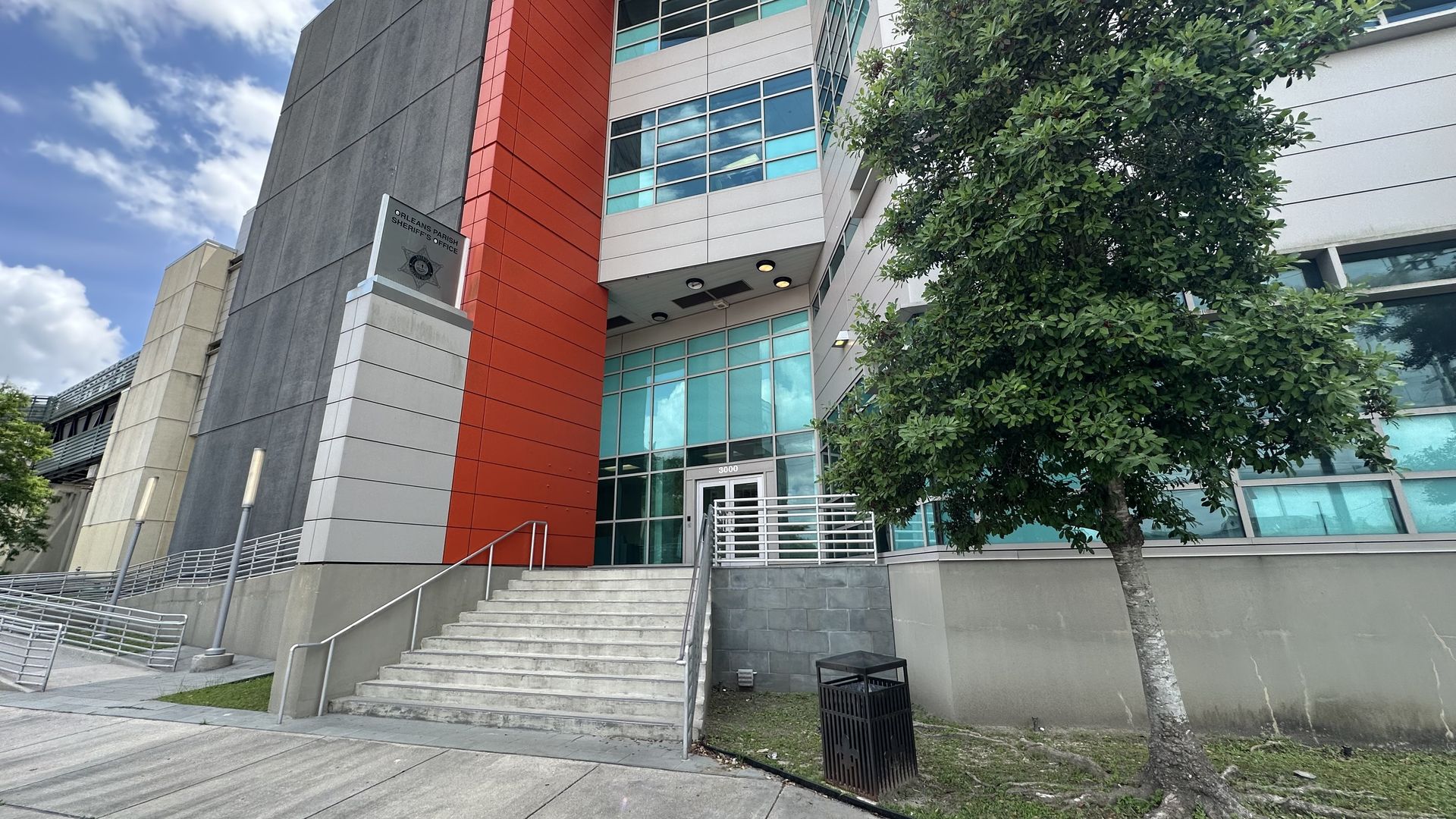 The facade of the Orleans Justice Center on a partly cloudy day.