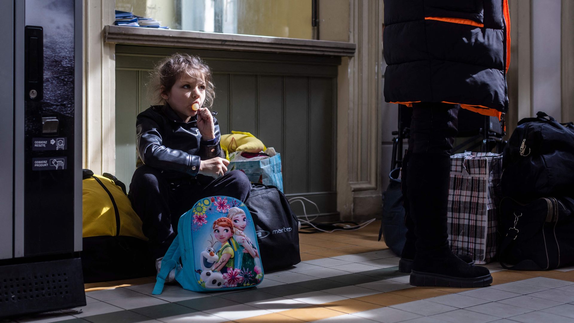 A refugee girl from Ukraine sits with her luggage in the ticket hall of the railway station in Przemysl, eastern Poland, April 7