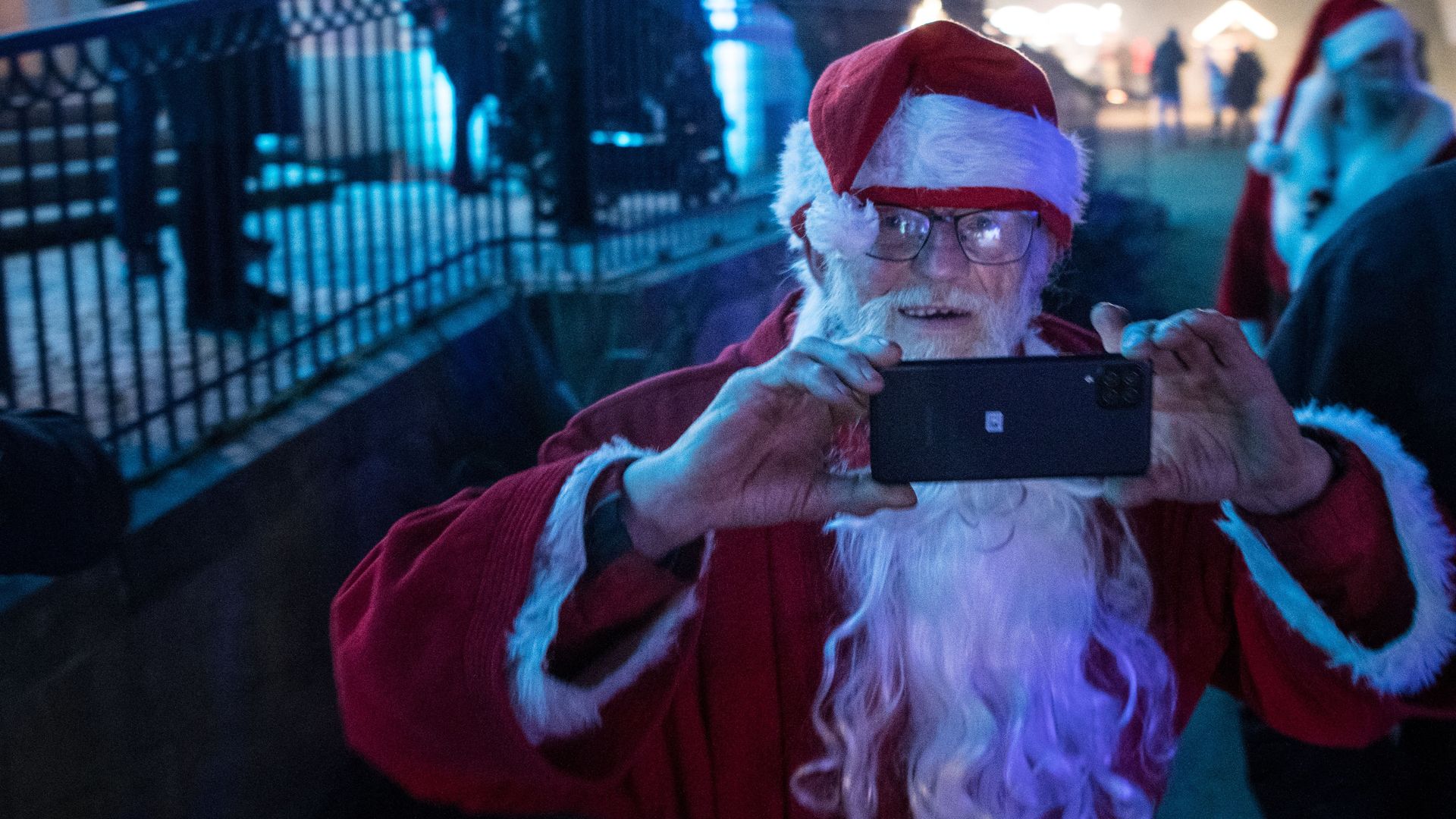 A man dressed as Santa Claus takes a picture during a Santa Claus General Assmbly