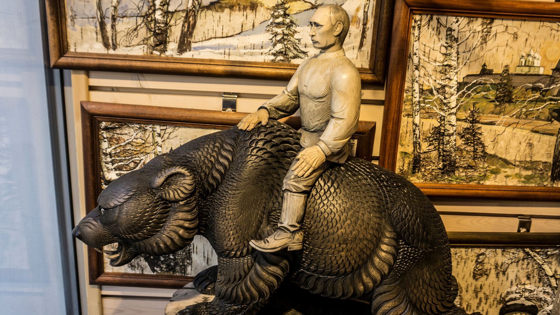 A wooden sculpture made of linden representing Russian President Vladimir Putin riding a bear at a souvenir shop in Saint Petersburg on June 28, 2017.