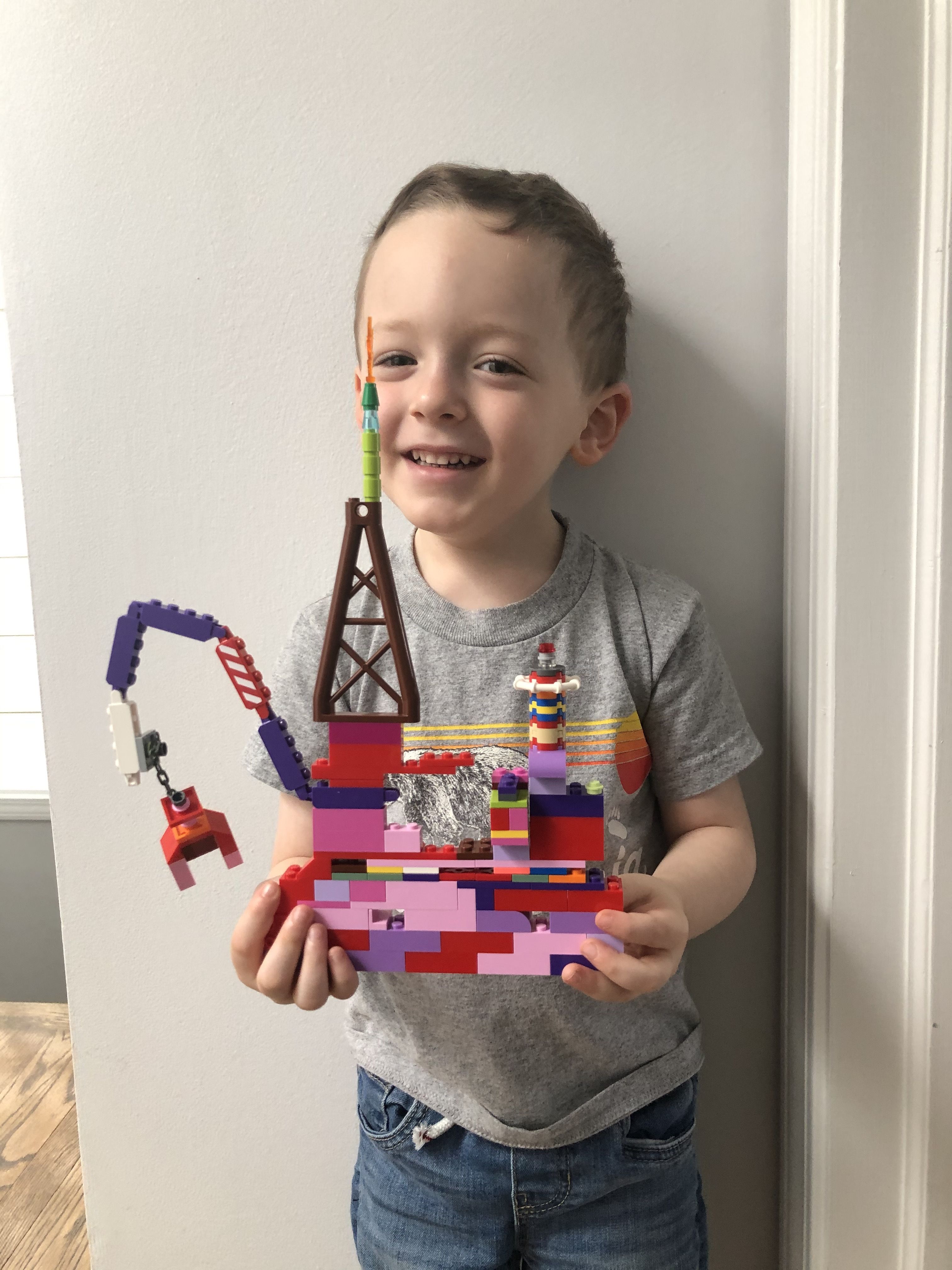A little boy named Rowan holds something he built out of legos