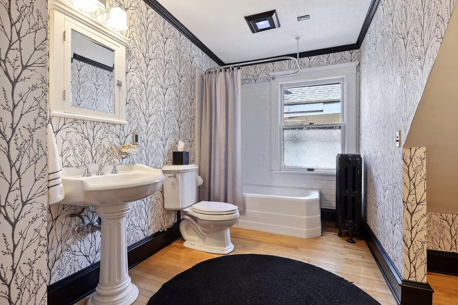 A photo of a bathroom with black and white wallpaper.