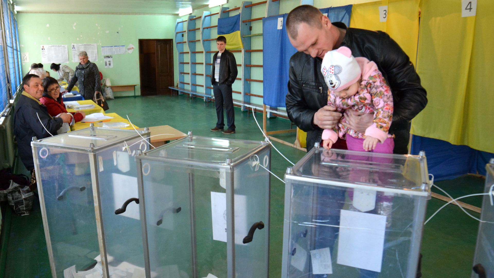 A man with his daughter casting his vote at a Ukrainian polling station