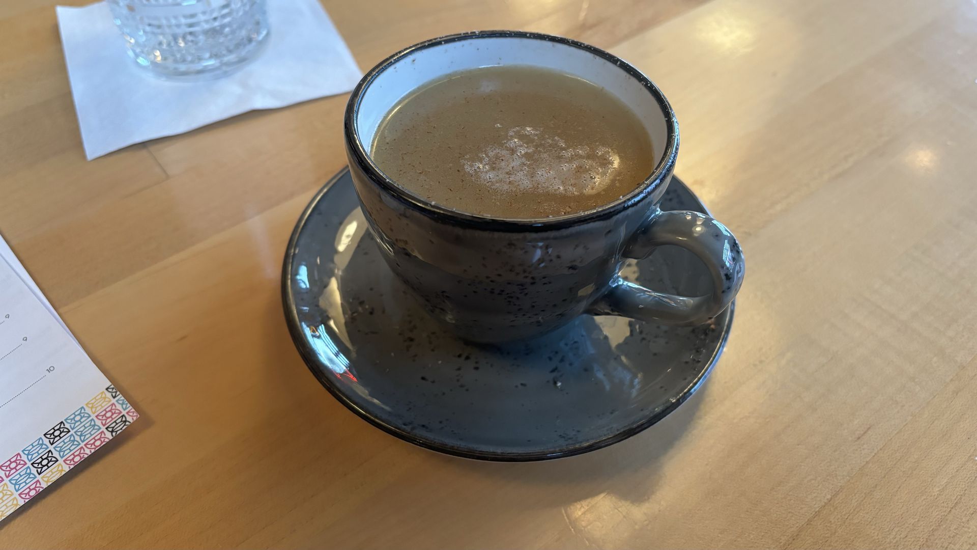 A drink on a wood counter with ceramic mug