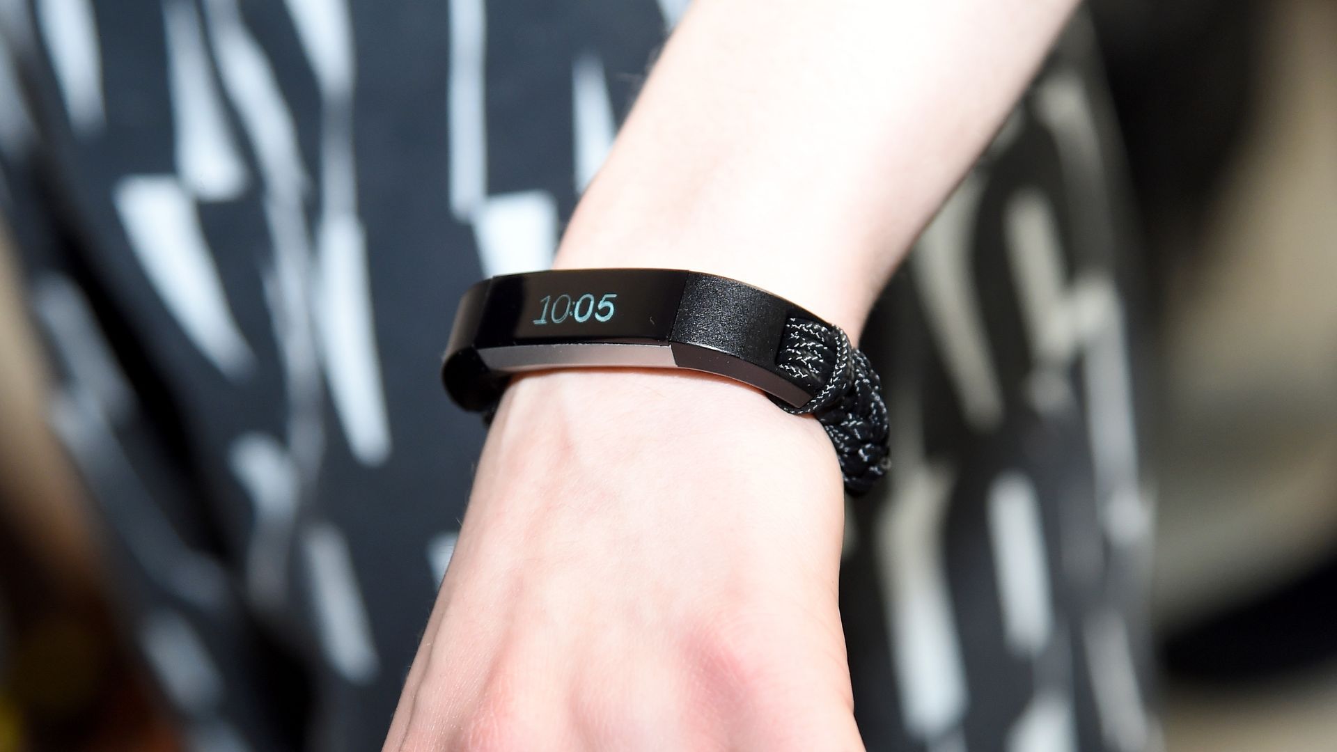 A hand wearing a FitBit.