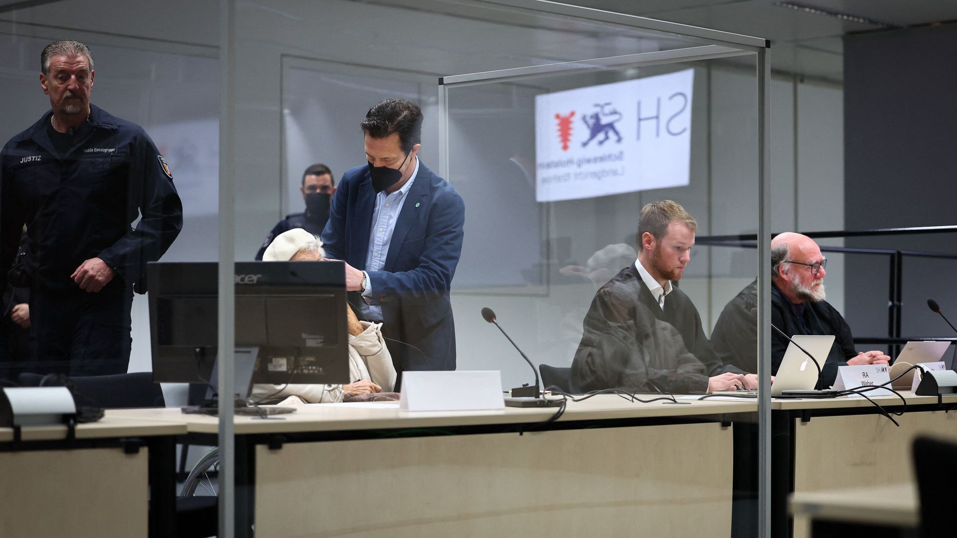 Defendant Irmgard F (2nd L) sits close to her lawyers Niklas Weber (2nd R) and Wolf Molkentin (R) in a courtroom in Itzehoe, northern Germany, where her verdict was spoken on December 20, 2022