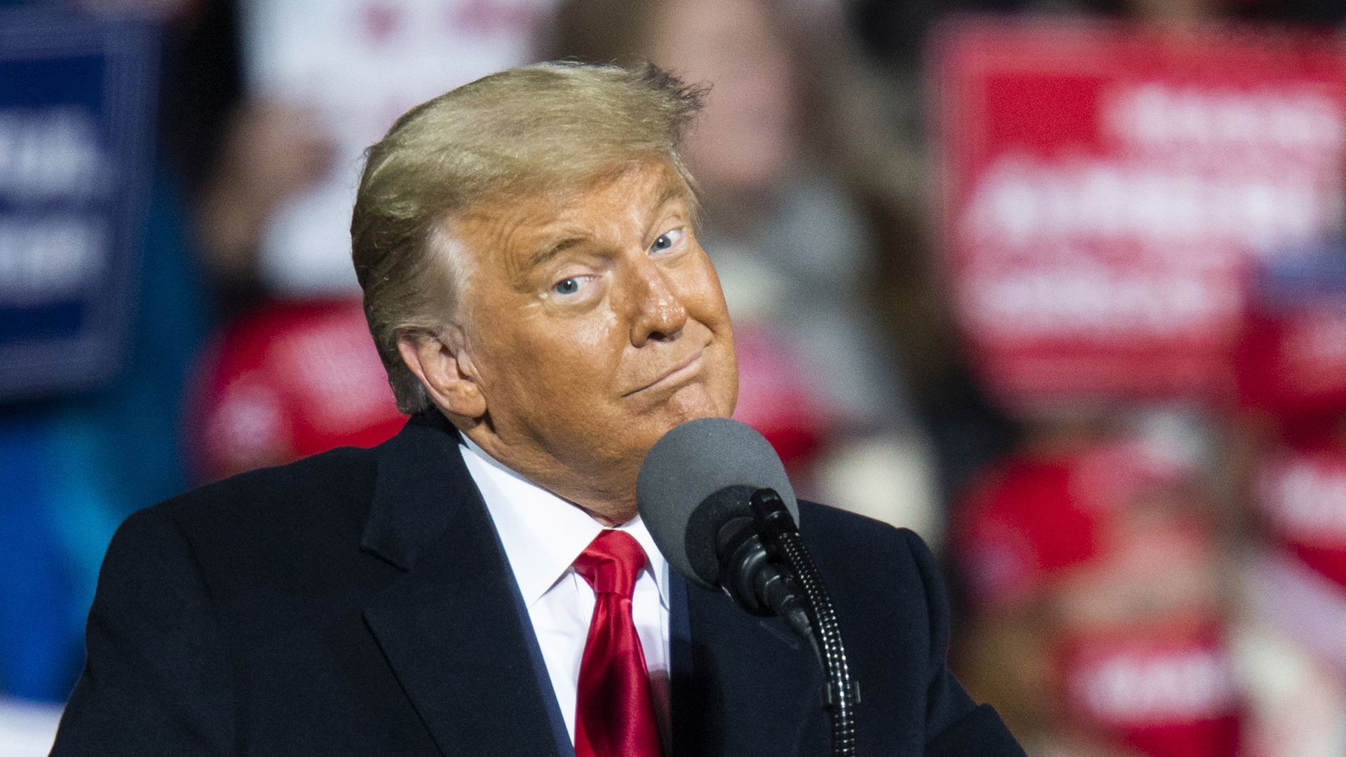 President Trump raises his eyebrows and tilts his face while addressing supporters at a rally