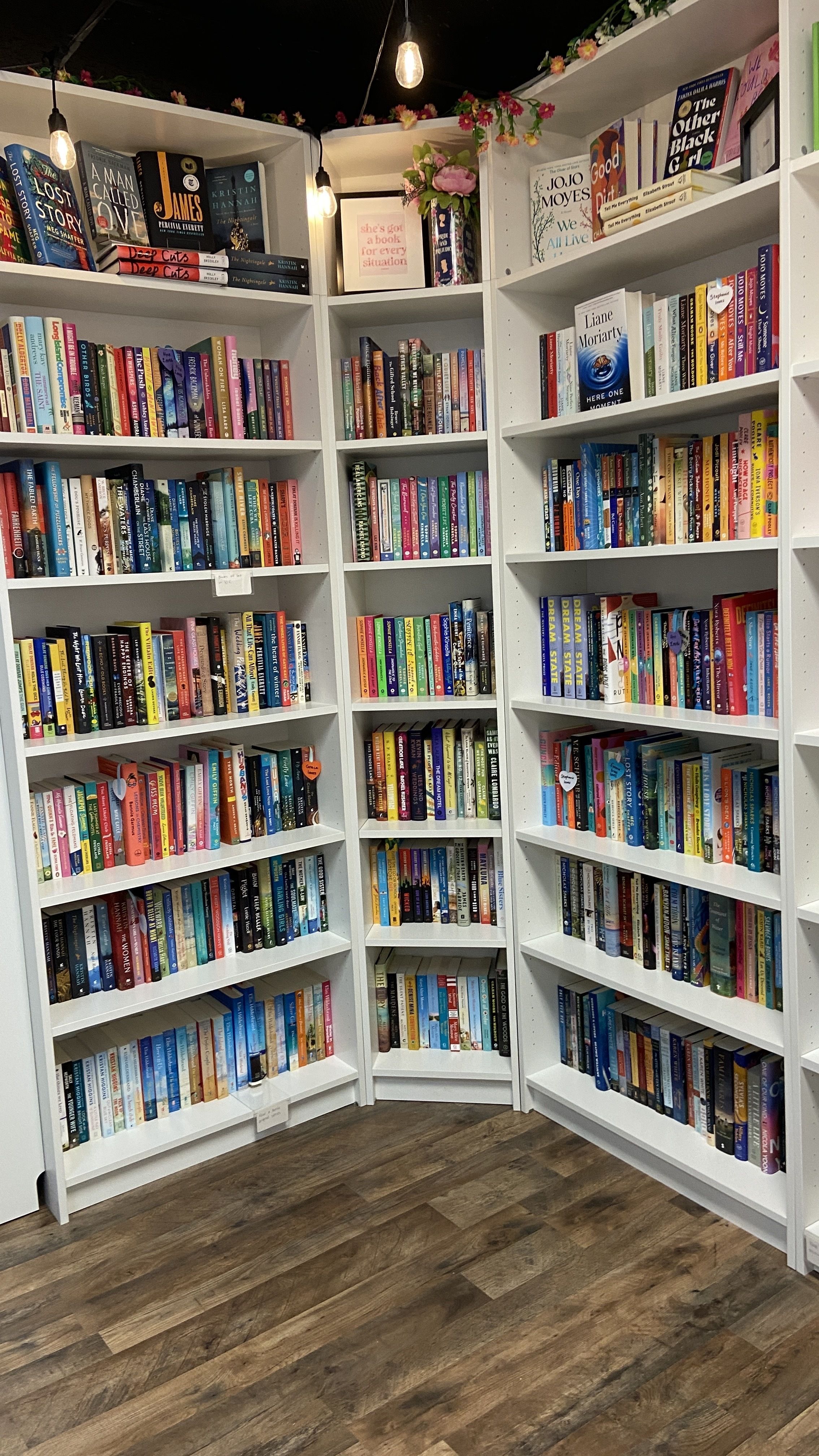 Books line white shelves. 