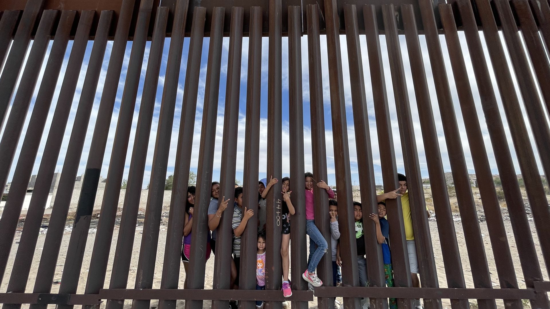 Children at the border of the Puerto de Anapra colonia of Ciudad Juárez, Mexico, hang on a border fence and look to Sunland Park, N.M. 