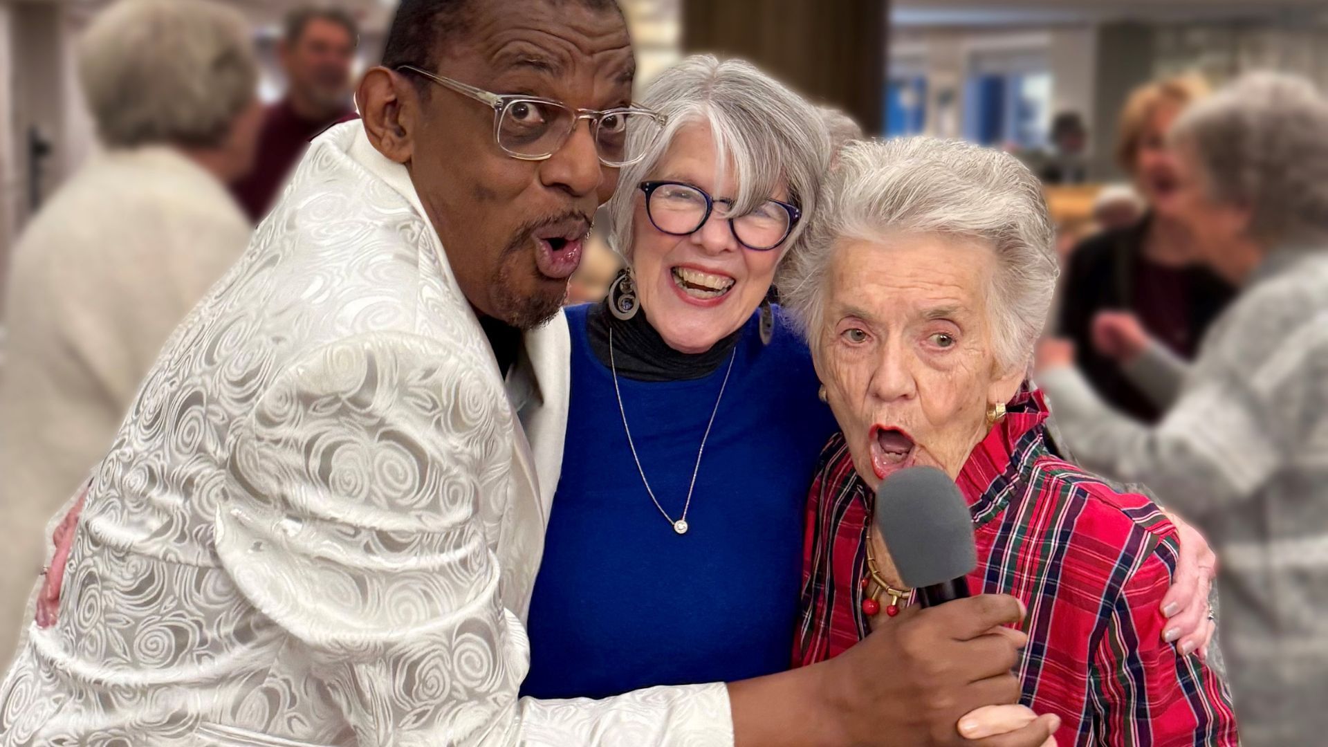 Three joyful older adults smiling and singing together, one holding a microphone, during a lively event.