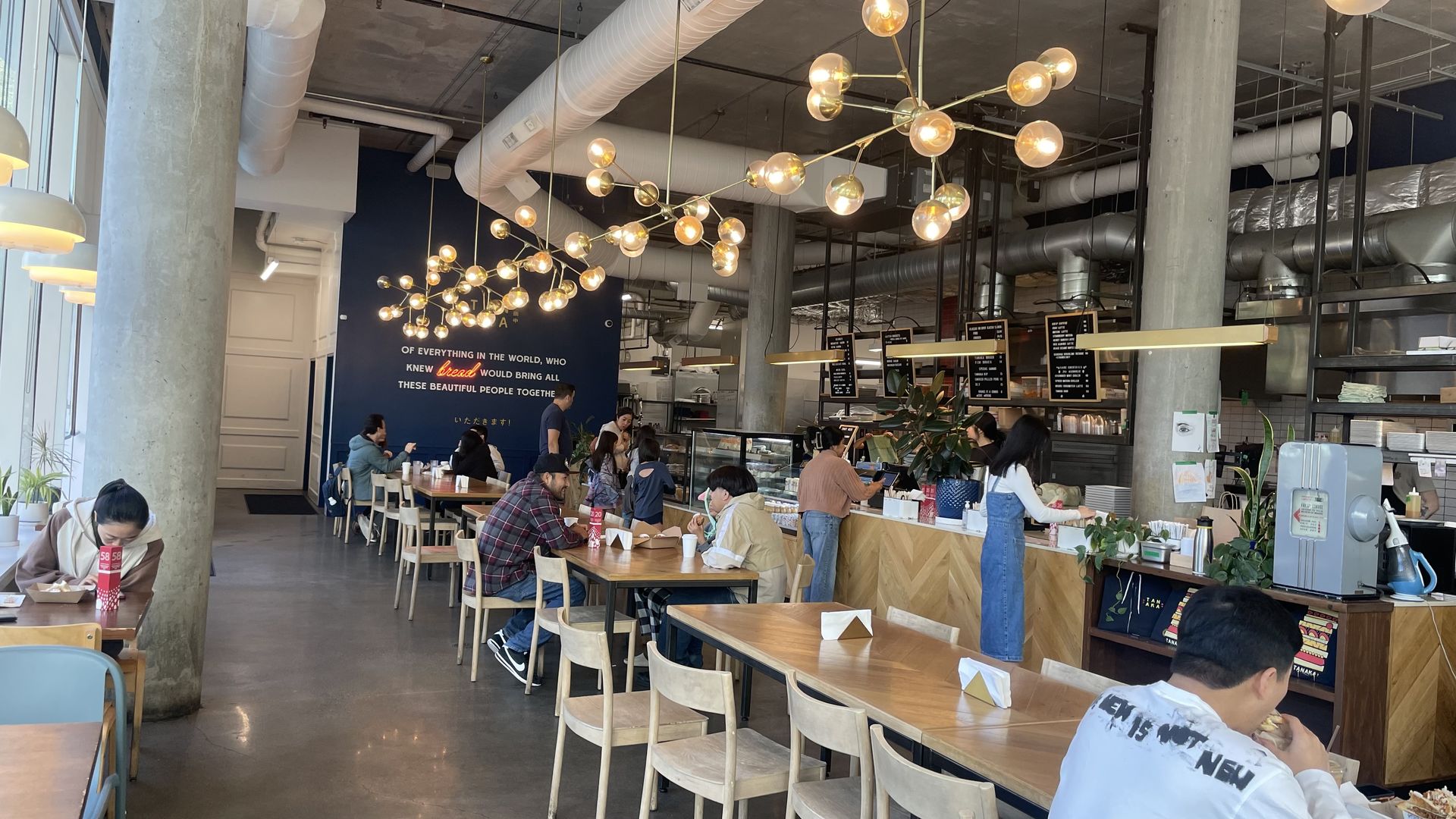 A photo of the inside of a restaurant with a series of multi-bulb chandeliers hanging from the ceiling.