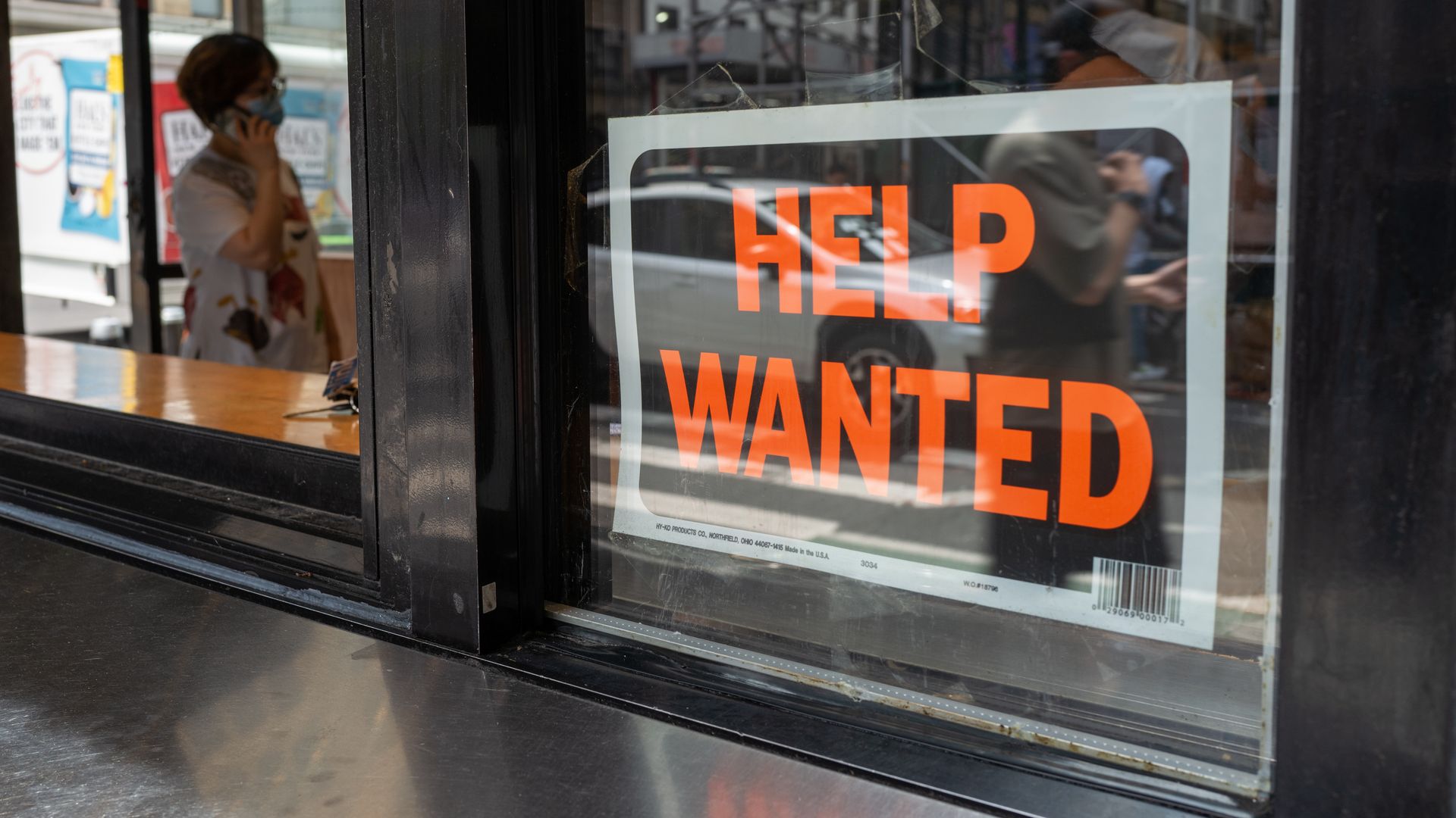 Photo of a "Help wanted" sign displayed in a window