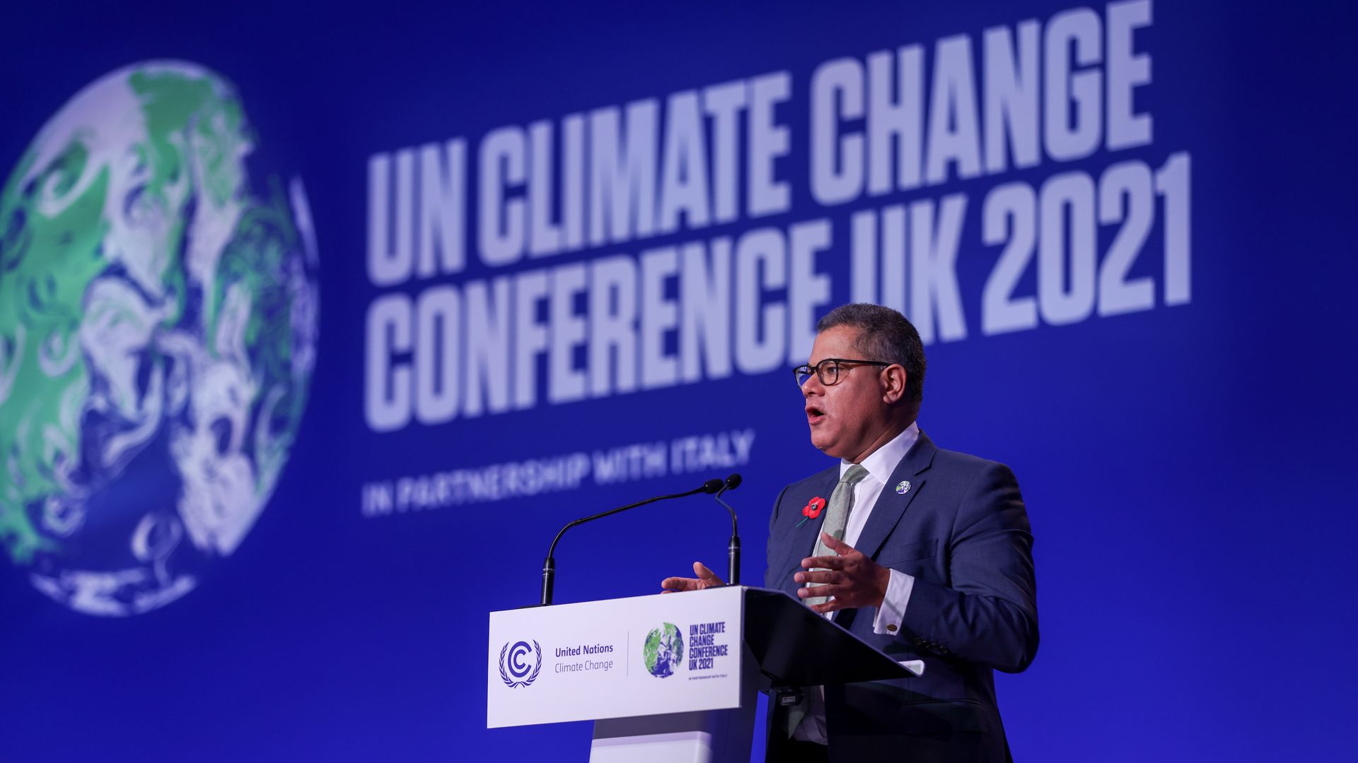 COP26 President Alok Sharma speaks at a podium in Scotland.
