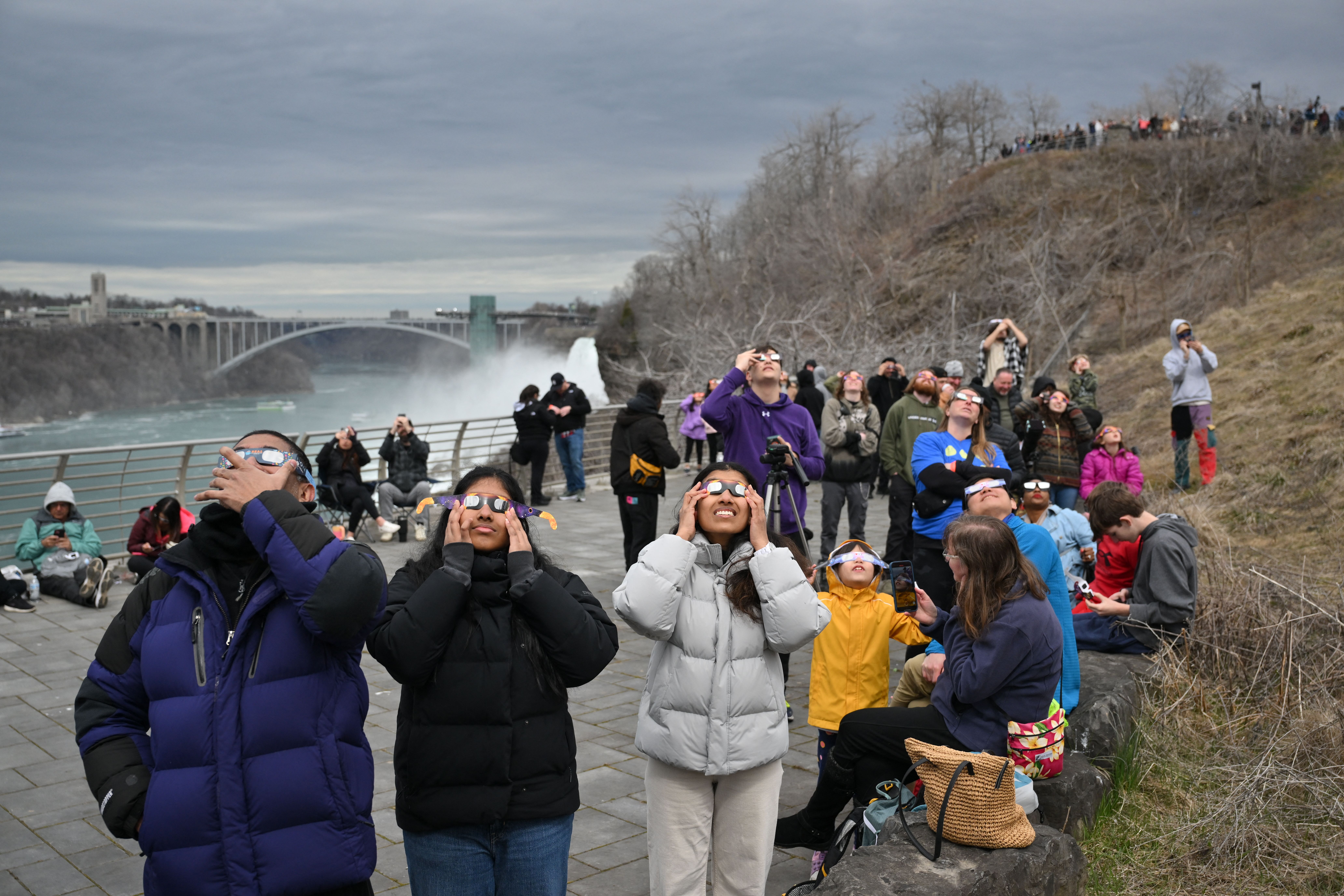 People look up at the sun during a total solar eclipse across North America, at Niagara Falls State Park in Niagara Falls, New York, on April 8, 2024. This year's path of totality is 115 miles (185 kilometers) wide and home to nearly 32 million Americans, with an additional 150 million living less than 200 miles from the strip. The next total solar eclipse that can be seen from a large part of North America won't come around until 2044. (Photo by ANGELA WEISS / AFP) (Photo by ANGELA WEISS/AFP via Getty Images)