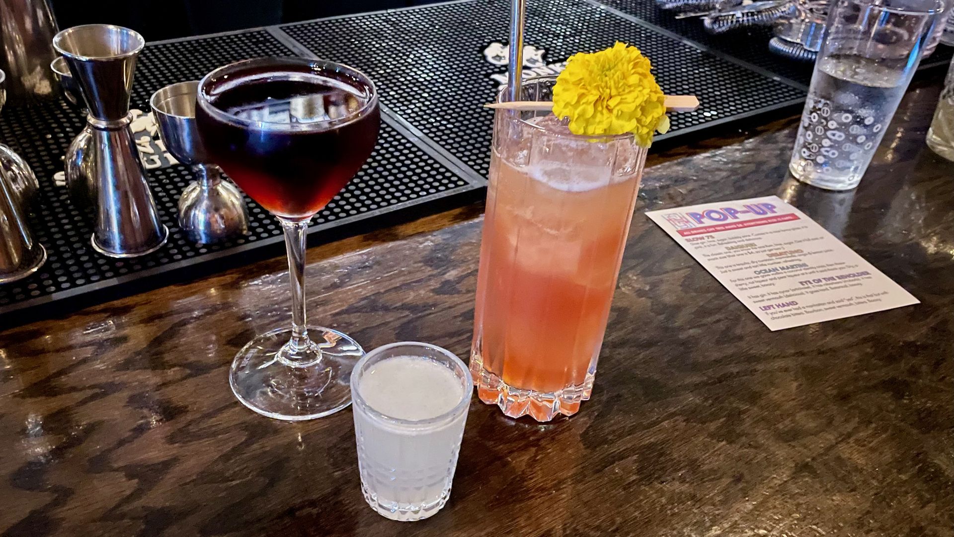 Three drinks sitting on a bar