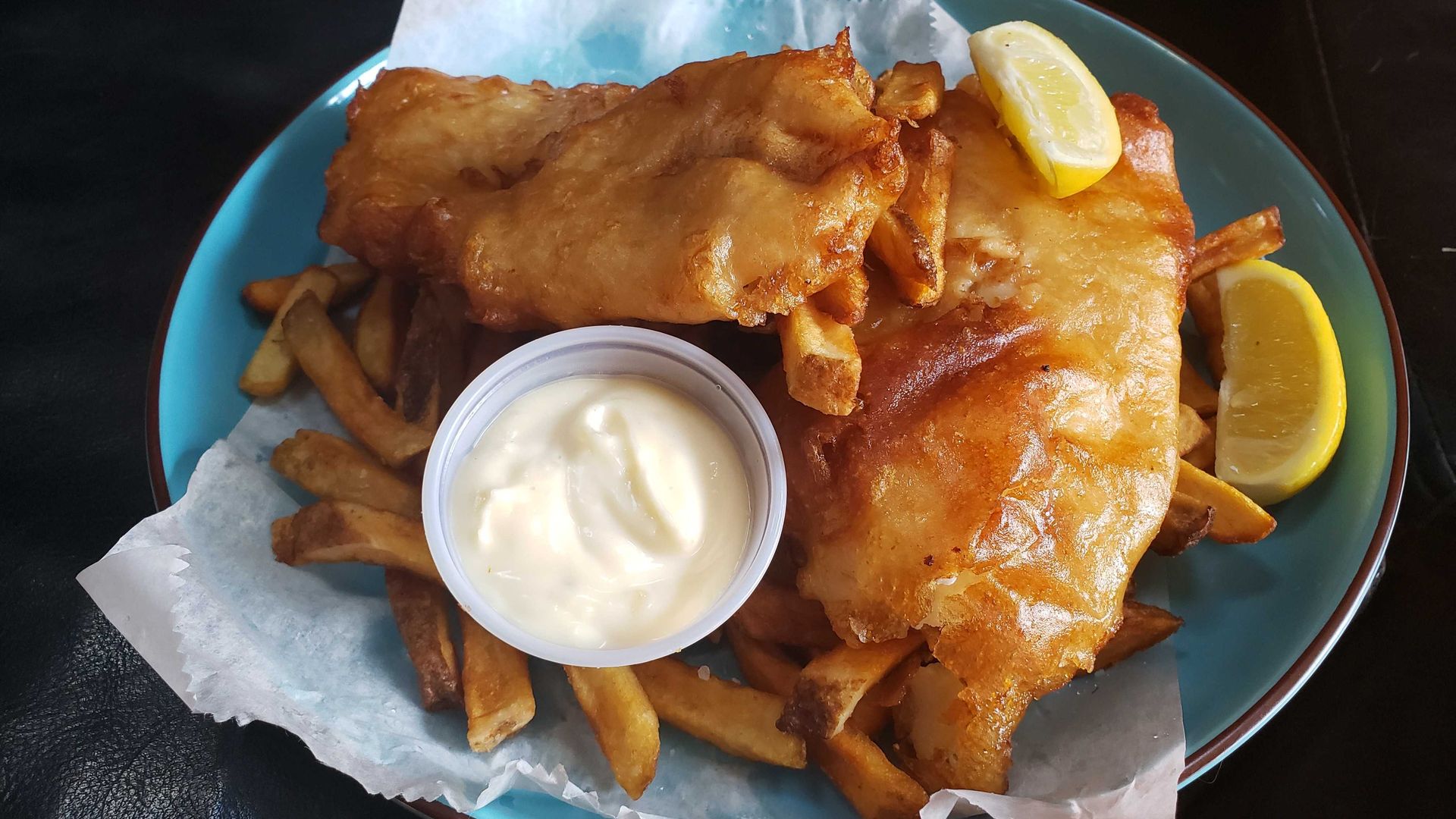 Photo of fried fish and fries on a plate.