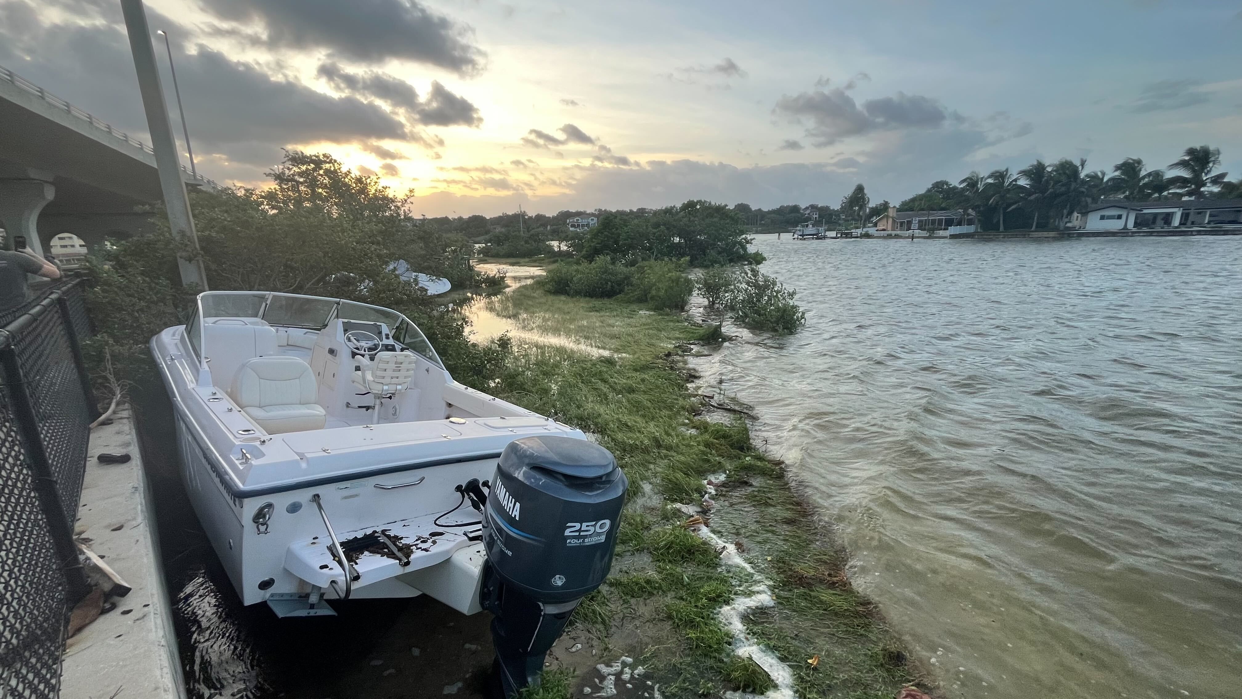 A white powerboat washed up on the shore under Belleaire Causeway