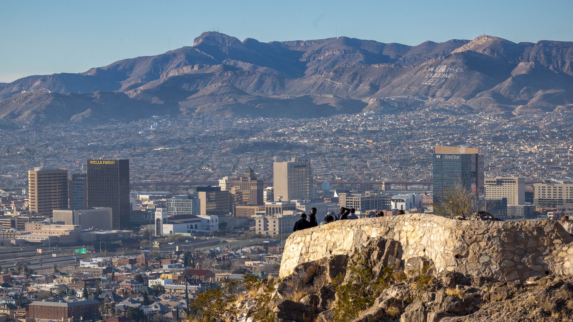 a picture overlooking the city of El Paso, Texas, with mountains in the foreground and tall buildings in the middle