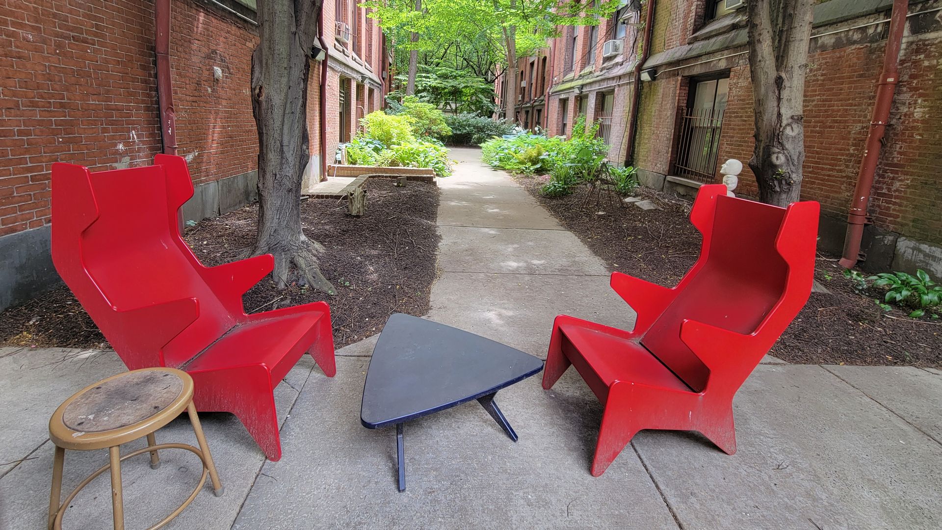 Two empty red chairs in a courtyard. Can you guess where Axios reporter Isaac Avilucea is?