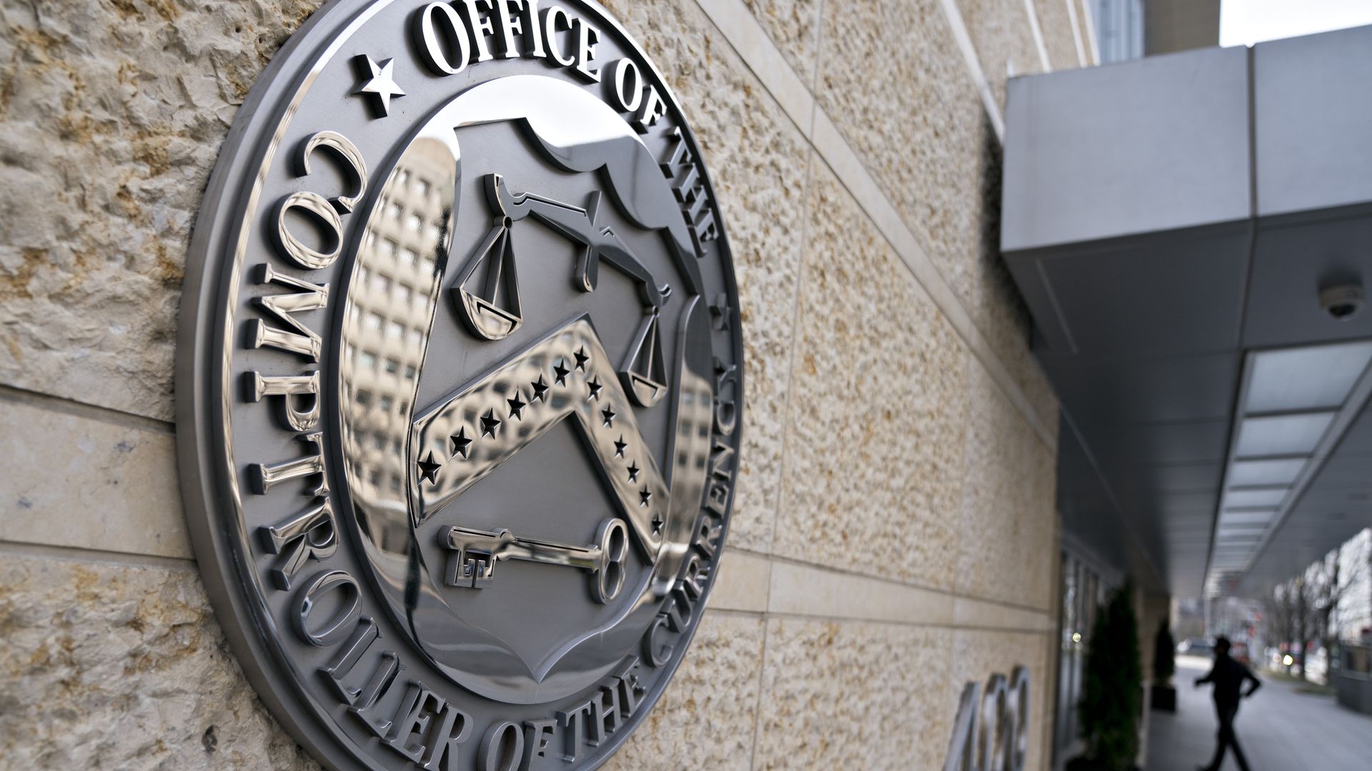 The seal of the Office of the Comptroller of the Currency (OCC) is displayed outside the organization's headquarters in Washington, D.C., U.S., on Wednesday, March 20, 2019. 