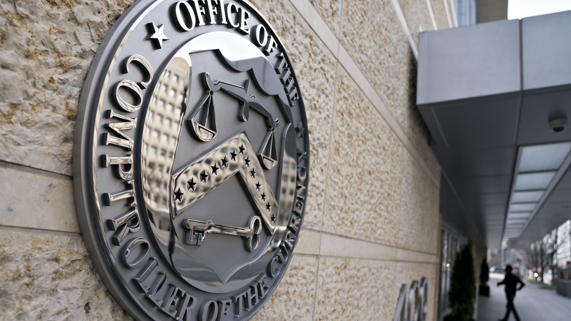The seal of the Office of the Comptroller of the Currency (OCC) is displayed outside the organization's headquarters in Washington, D.C., U.S., on Wednesday, March 20, 2019.