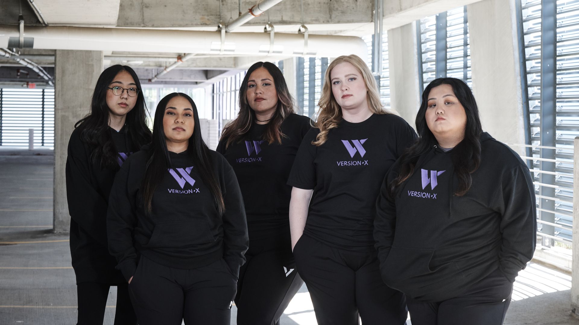 five women standing in parking garage in Versionx hoodies