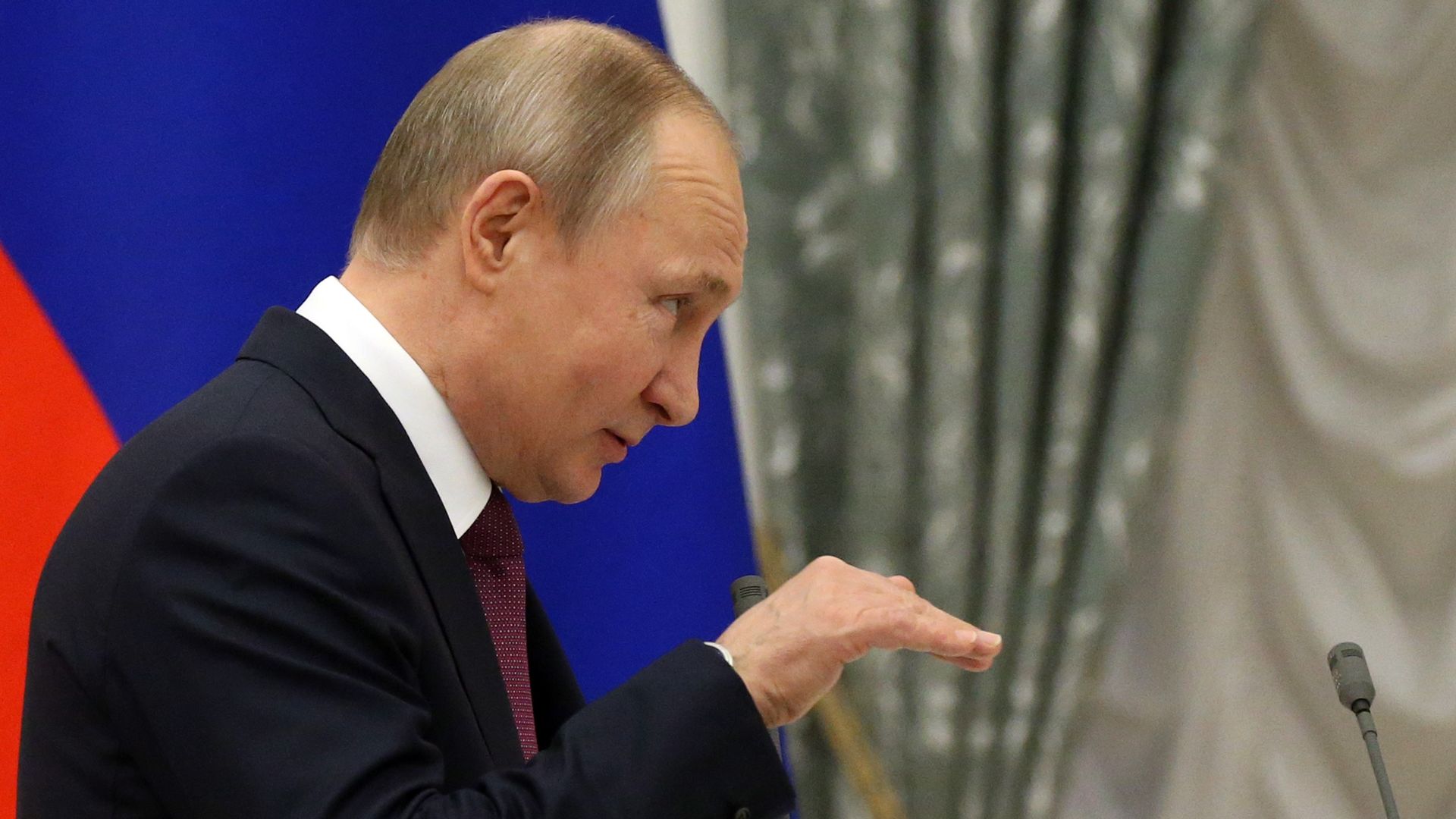 Vladimir Putin gestures with his hand.