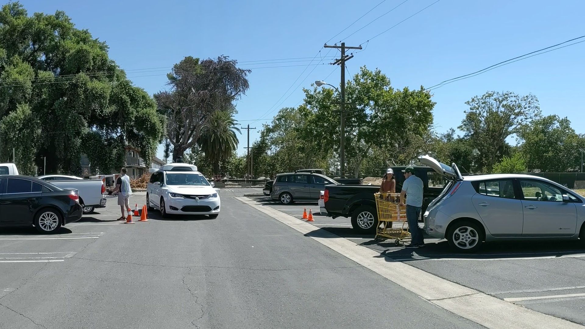 Image of Waymo self-driving van navigating a parking lot during testing.