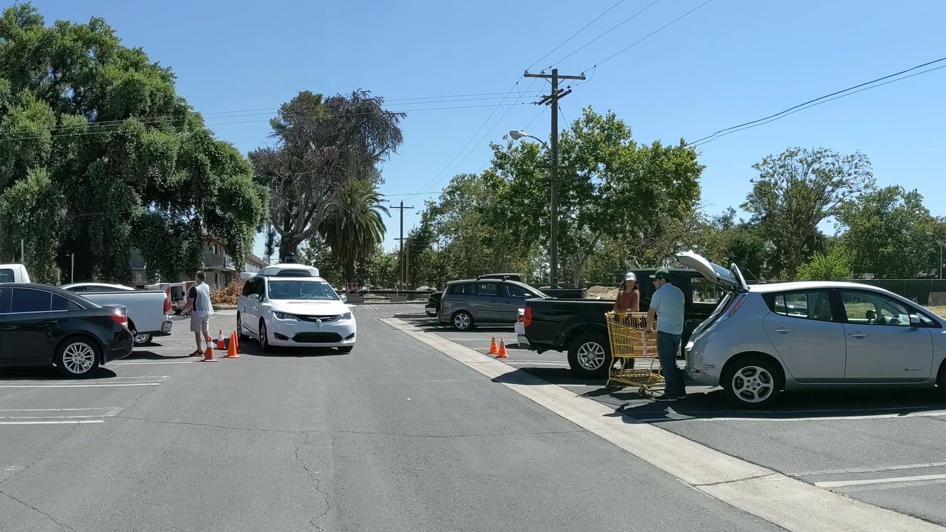 Image of Waymo self-driving van navigating a parking lot during testing. 