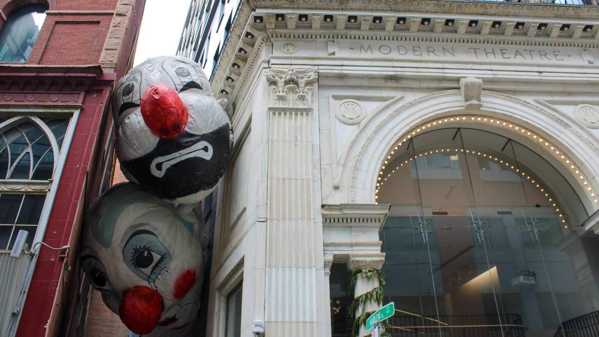 "End Game," an art installation featuring two massive floating clown heads, hovers between the Modern Theatre and the building nextdoor in downtown Boston. It's part of an art series called "Winteractive" led by the Boston Business Improvement District.