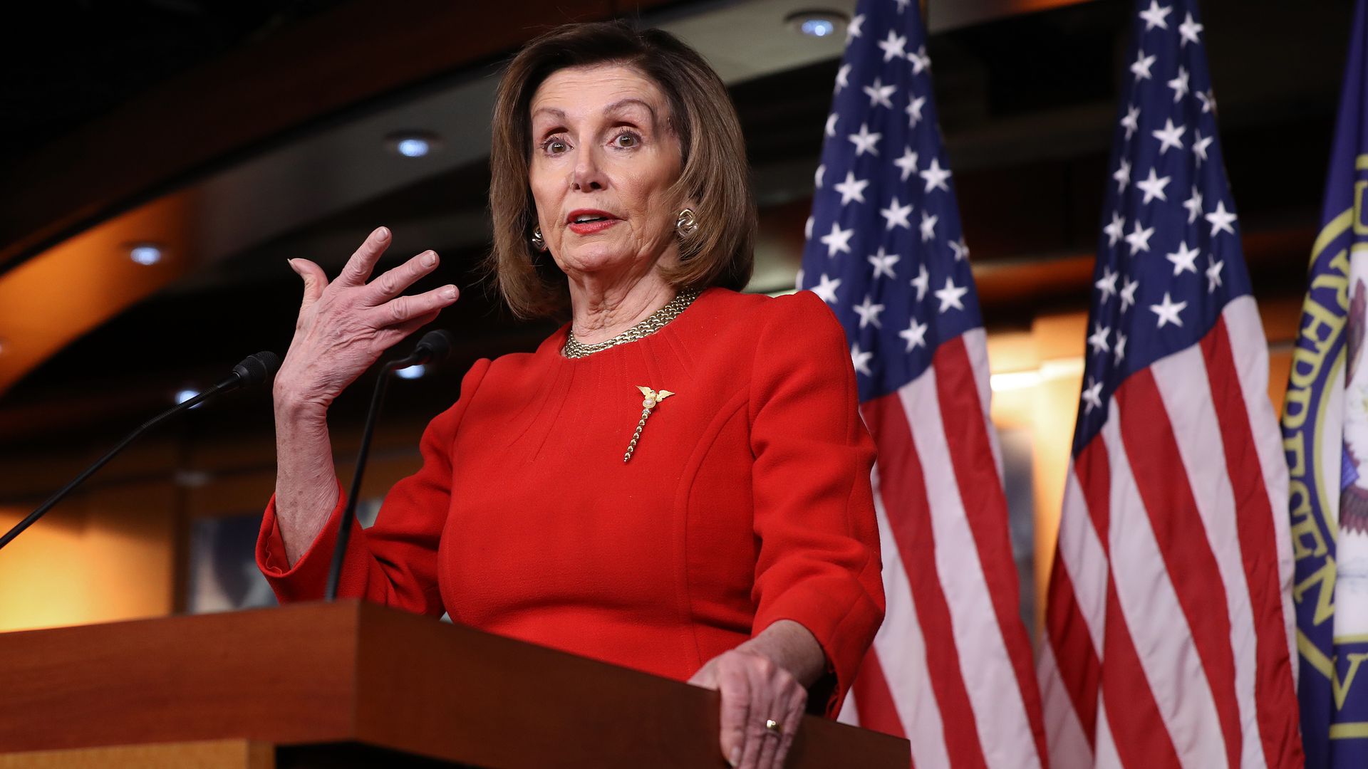 Nancy Pelosi at a podium.